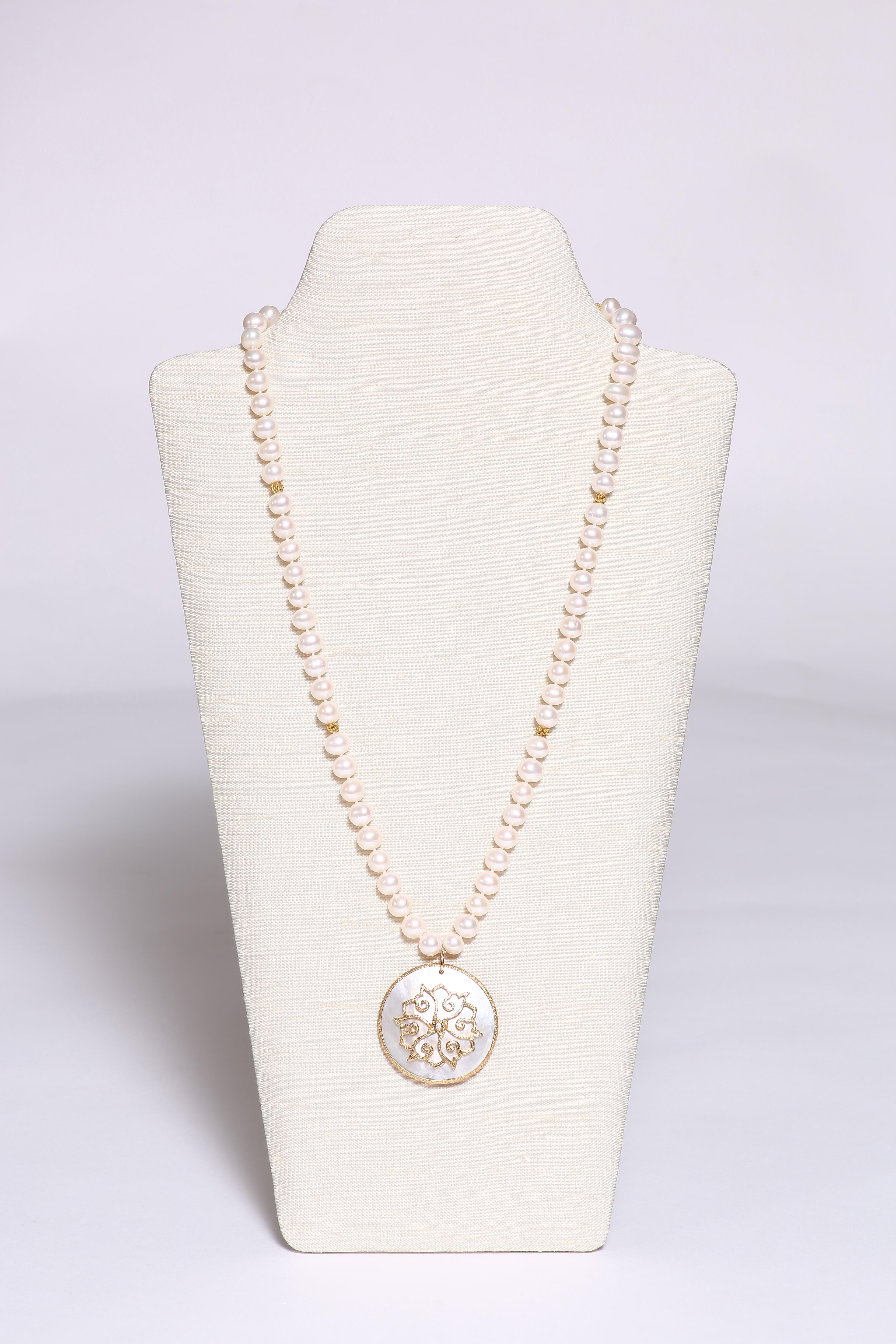 A beautiful Mother of Pearl pendant, decorated with hand-worked 18k gold lotus and a diamond studded in the center. Freshwater pearls form the necklace with six small 18k faceted gold beads and a sphere-shaped clasp.