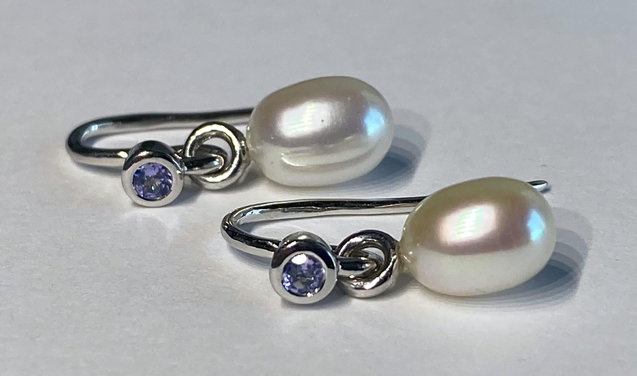 14kt White Gold & Silver Earrings, set with Tanzanite and Freshwater Pearls on a French Hook. The pearls dangle  from a hoop. 

Originally from San Diego, California, Kary Adam lived in the “Gem Capital of the World” - Bangkok, Thailand, sourcing