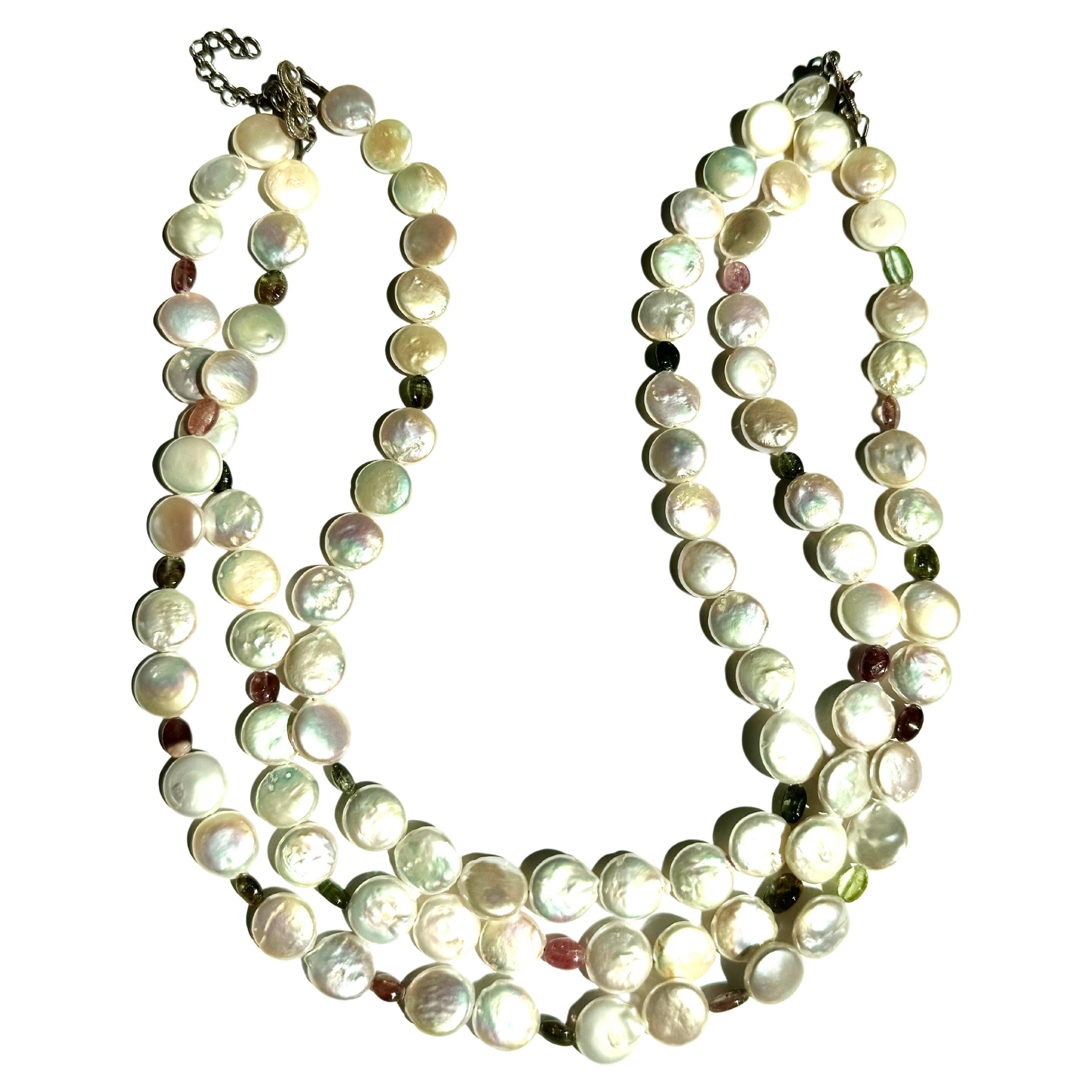 Collana a tre fili con perle d'acqua dolce e tormalina 
Pere d'acqua dolce a tre fili, fatte a mano, con lustro a moneta  e perline ovali multicolore di tormalina, chiusura in argento. Lunga circa 16