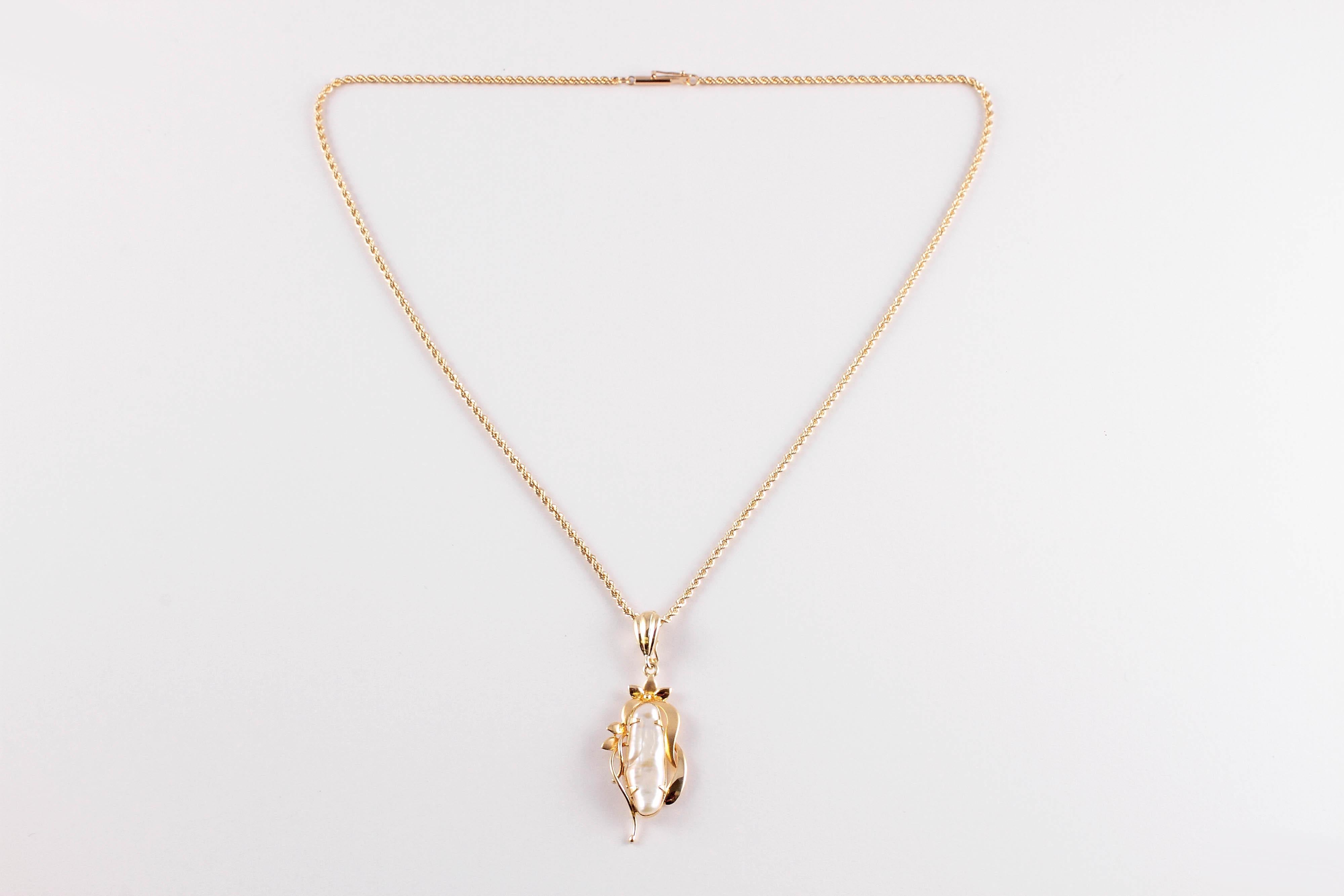 Unusual and elongated!  This lovely freshwater pearl pendant is suspending from and 18 inch, yellow gold, twisted rope chain.