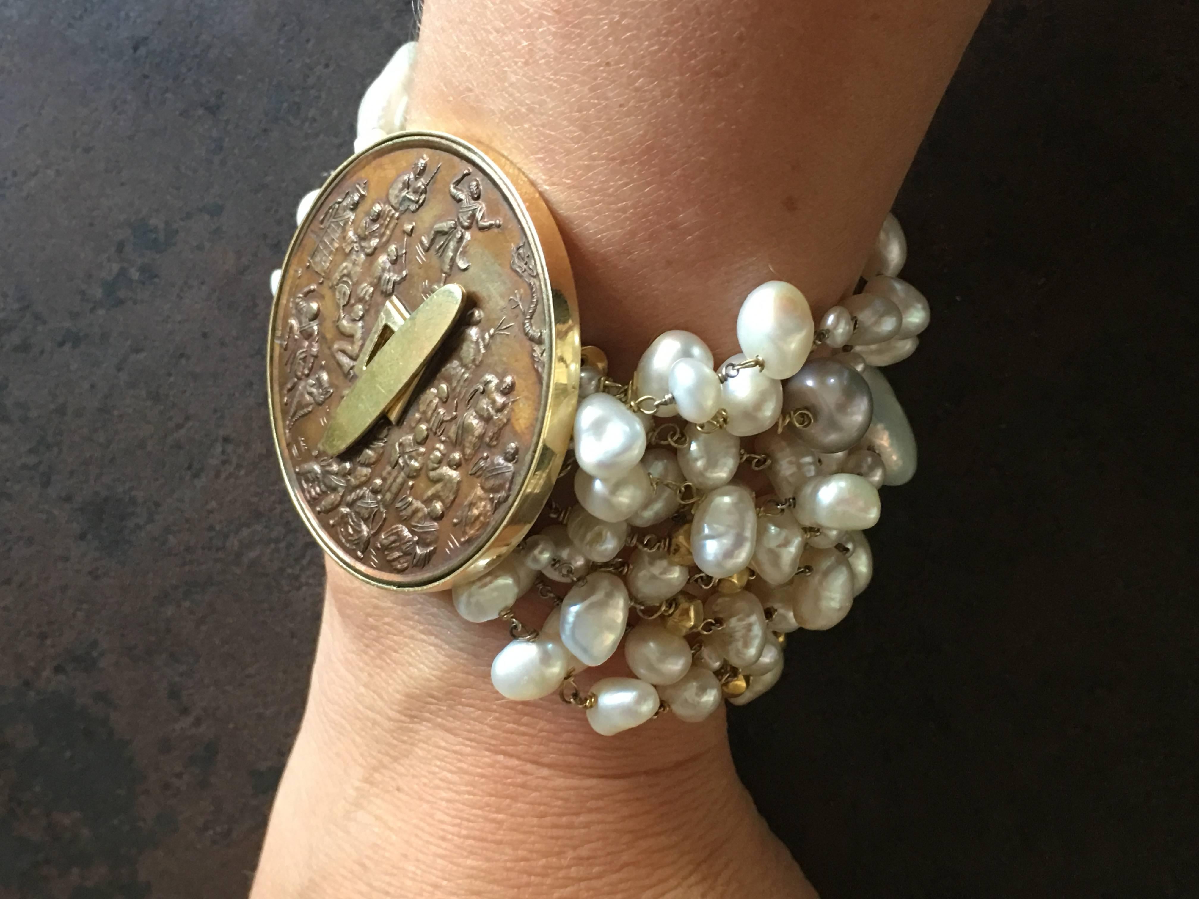Bracelet with different color and shape of freshwater pearls, antiques Indian faced gold beads, closure with antiques Chinese carved bronze coin representing few sages, gold.
All Giulia Colussi jewelry is new and has never been previously owned or