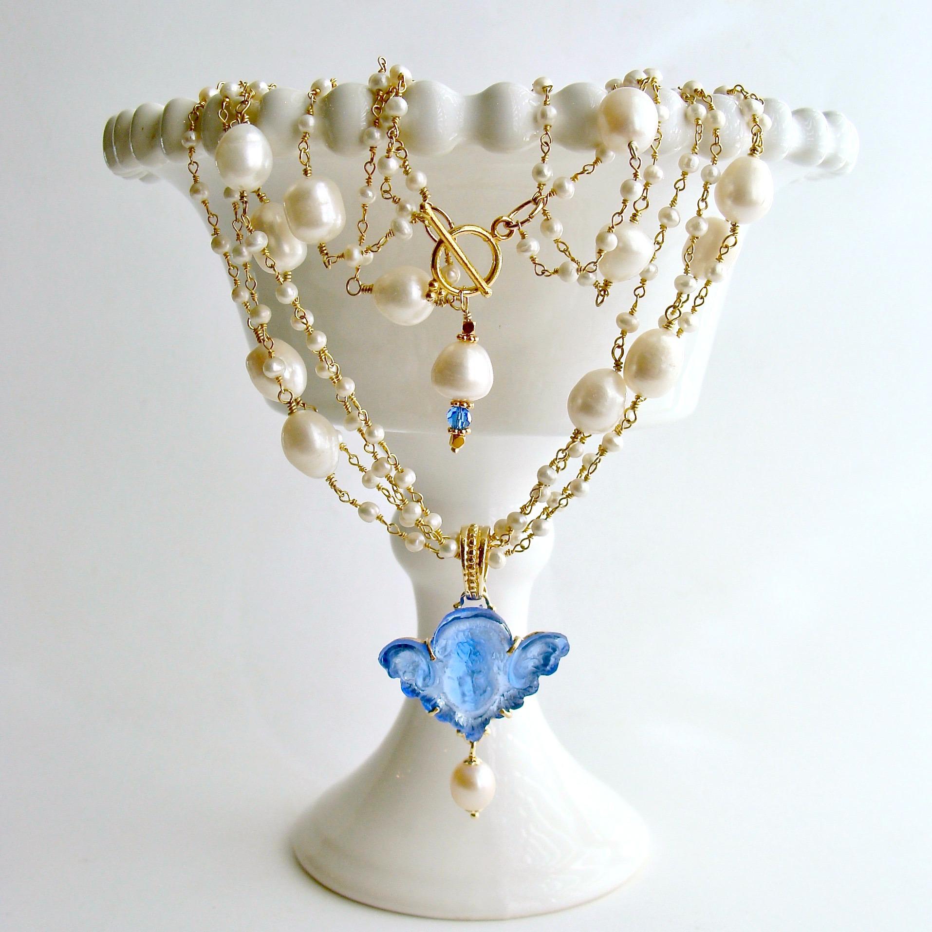 Taormina II Cherub Necklace.

The elegant beauty of simple strands of hand-linked creamy satin pearls, intercepted by larger baroque pearls, is the perfect compliment to this neoclassical cornflower blue Venetian glass cameo/intaglio cherub pendant.