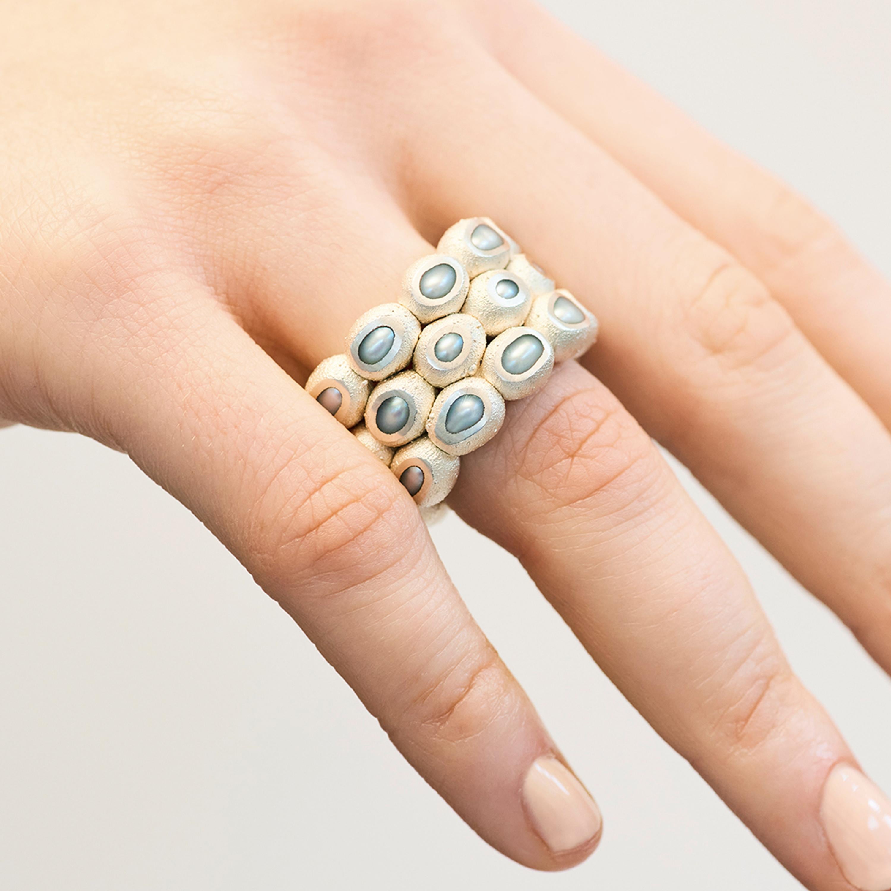 Ambroise Degenève’s Pearl Band Ring belongs to the designer’s ‘Fossilized Pearls’ collection. This intricate piece is created from freshwater pearls fossilised in copper and silver 925. The beautiful texture of this ring contrasts against the soft