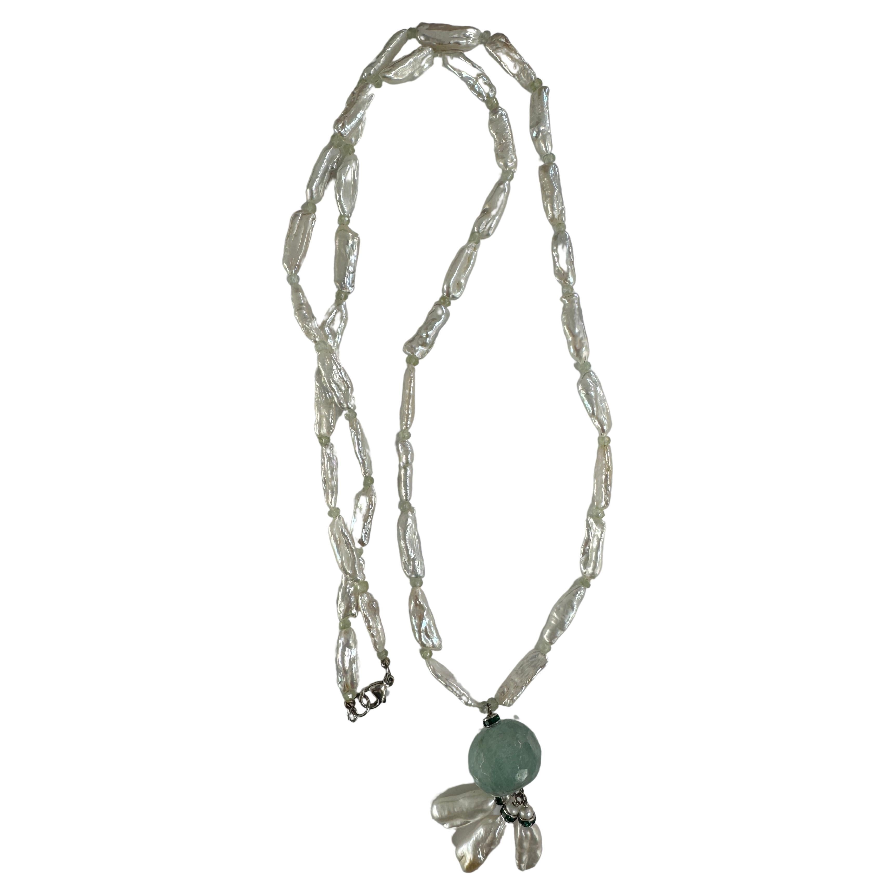 Freshwater white boroque pearls with aquamarine pendant necklace.
Handmade one of a kind  long necklace with large about 1inch aquamarine pendant and small aquamarine beads between white luster pearls. Sterling silver clasp. About 19