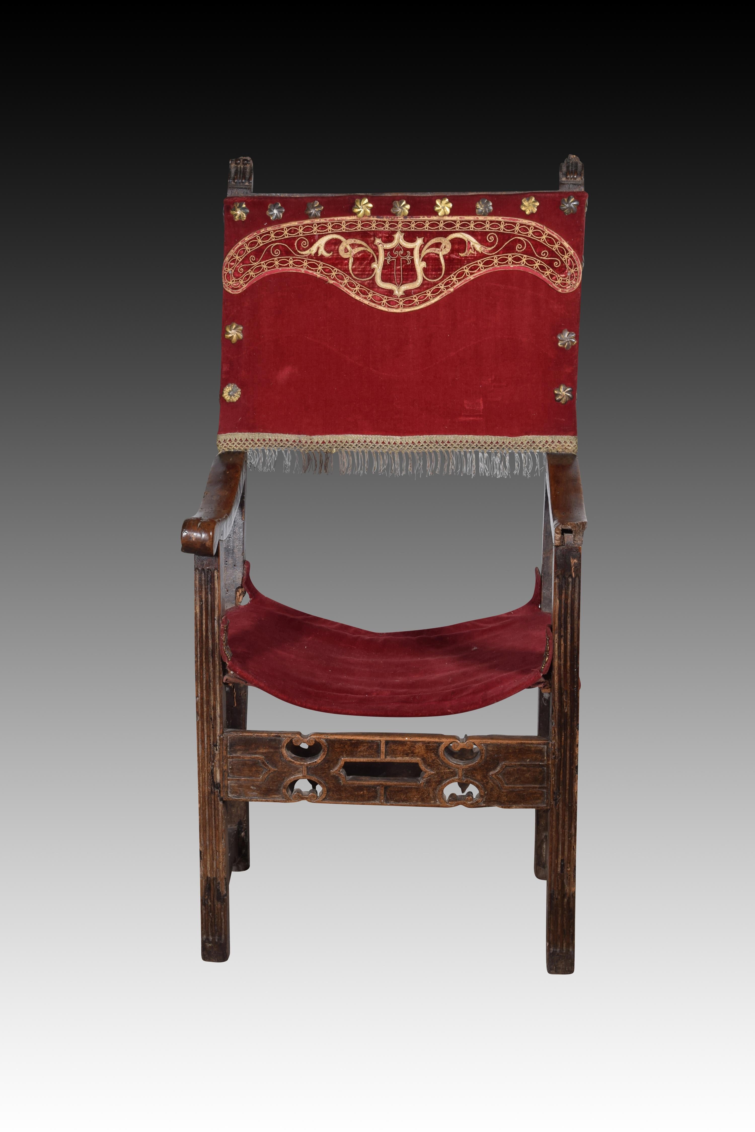 Friar armchair. Walnut wood, textile, metal. Spain, 16th century. 
Has defects. 
Armchair with arms and high back of the type known as “frailero”, which has a textile upholstery with studs on the seat and back, low cut-out profile chambrances