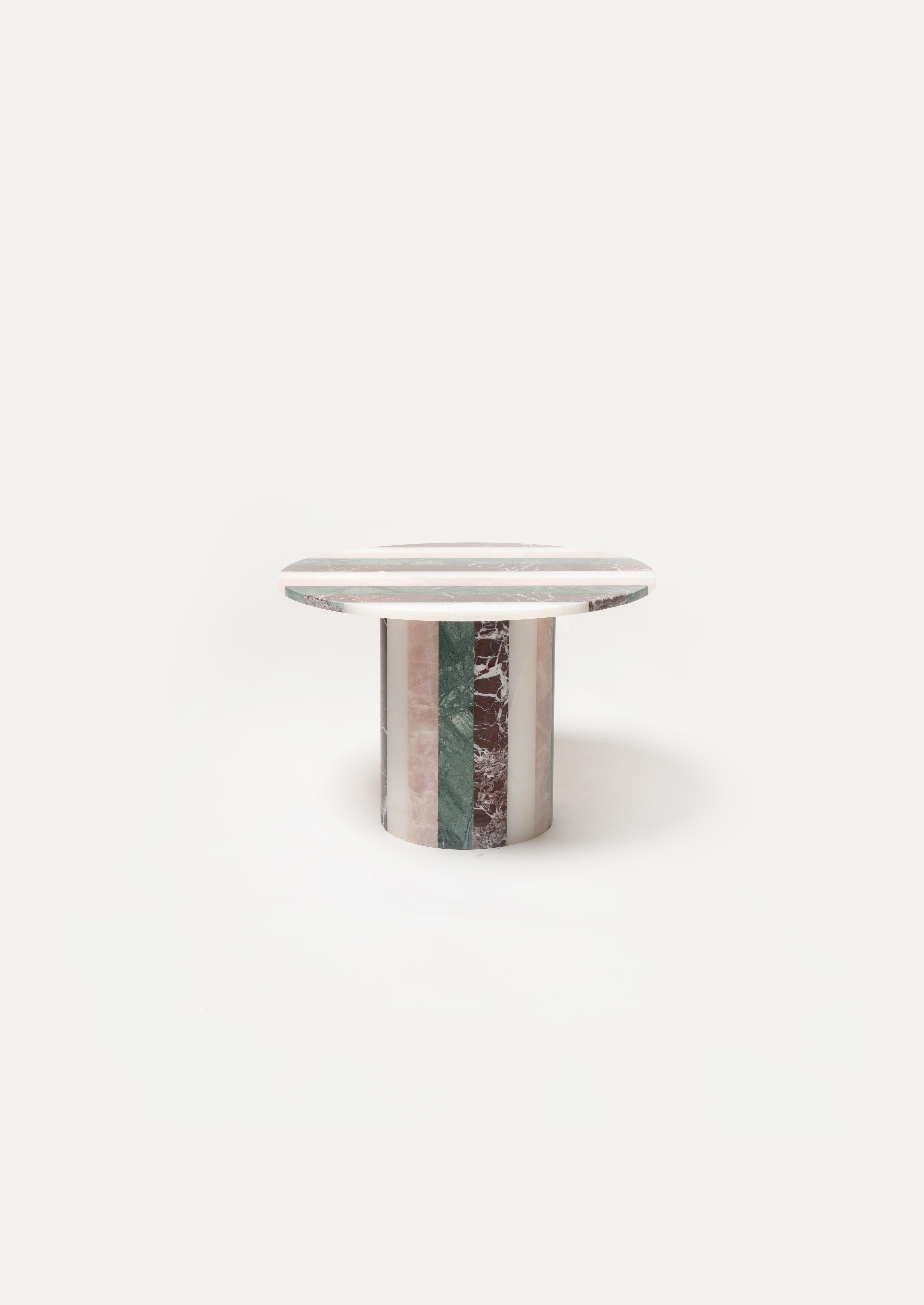 An exceptional collectible piece, the Frida table showcases the signature striped aesthetic of Studio Gaïa, meticulously assembled by hand. This sculptural table combines four noble stones: Rosso Levanto, Green Marble from the Alps, White Onyx, and