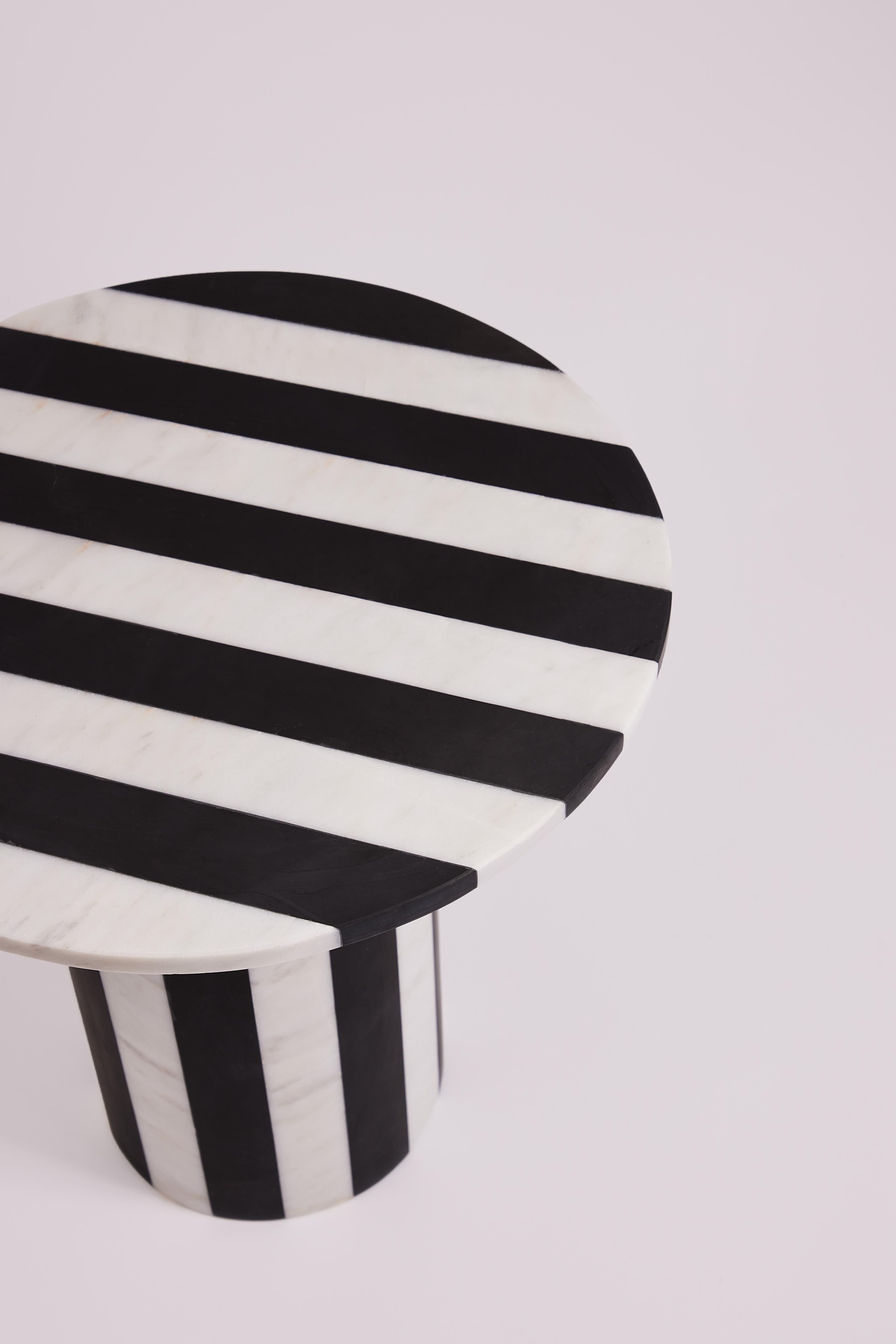 The Frida Black and White Marble Side Table is a stylish and functional piece of furniture that adds a touch of sophistication to any space. This table is crafted from high-quality marble, skillfully combining black and white colors to create a