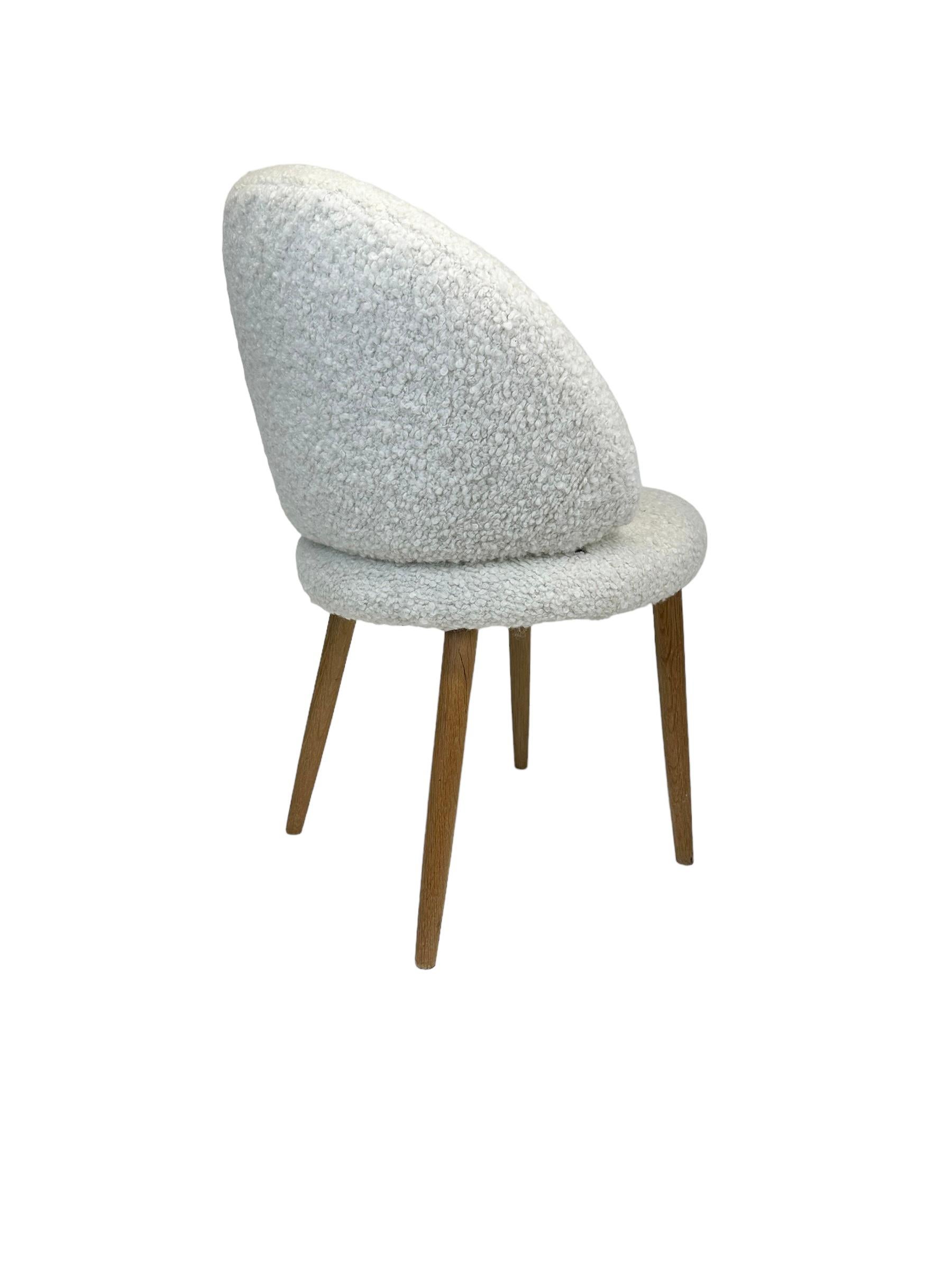 Beautiful and elegant diminutive vanity chair designed by Frode Holm. Executed in new cream bouclé textile, and comfortable supportive foam seat and back, with blonde solid wooden legs in satin lacquer finish. In good condition and presents well. In