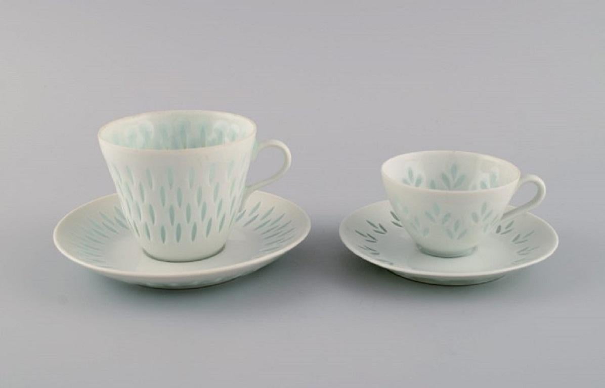 Friedl Holzer-Kjellberg (1905-1993) for Arabia. 
Two sets of coffee cups with saucers, creamer and dish in rice porcelain. 
Mid-20th century.
Smallest cup measures: 7 x 4.5 cm.
Smallest saucer diameter: 11.5 cm.
Dish diameter: 25.5 cm.
Signed.
In