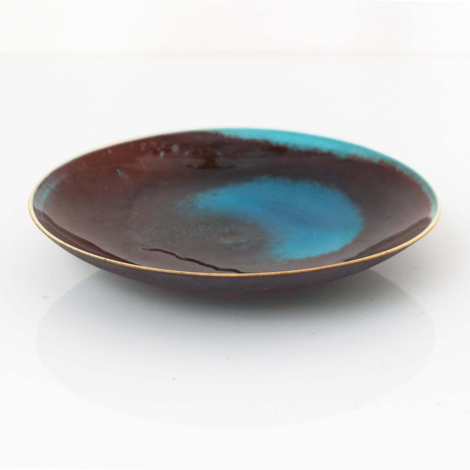 Friedl Holzer-Kjellberg Mid-Century Modern stoneware plate glazed deep red and vibrant blue made for Arabia, Finland. Kjellberg's design style has been characterized as 'modern classicism'; based on tradition, but tempered by clean simplicity. She