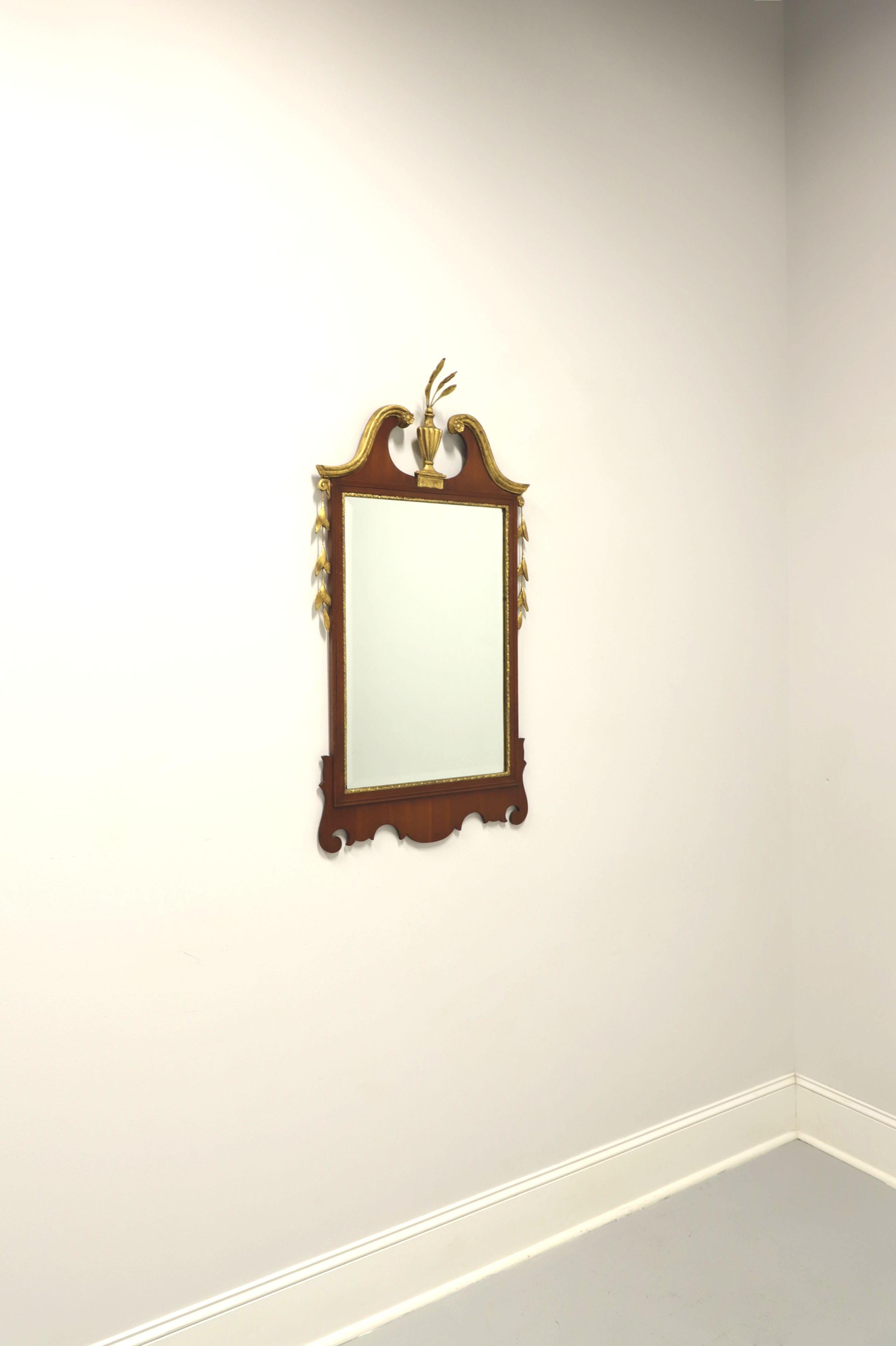 A Traditional style wall mirror by Friedman Brothers. Beveled mirrored glass in a mahogany frame with decoratively carved gold trim and center surmounted by gilded carved Prince of Wales Plumes. Made in the USA, in the mid 20th Century.

Measures: