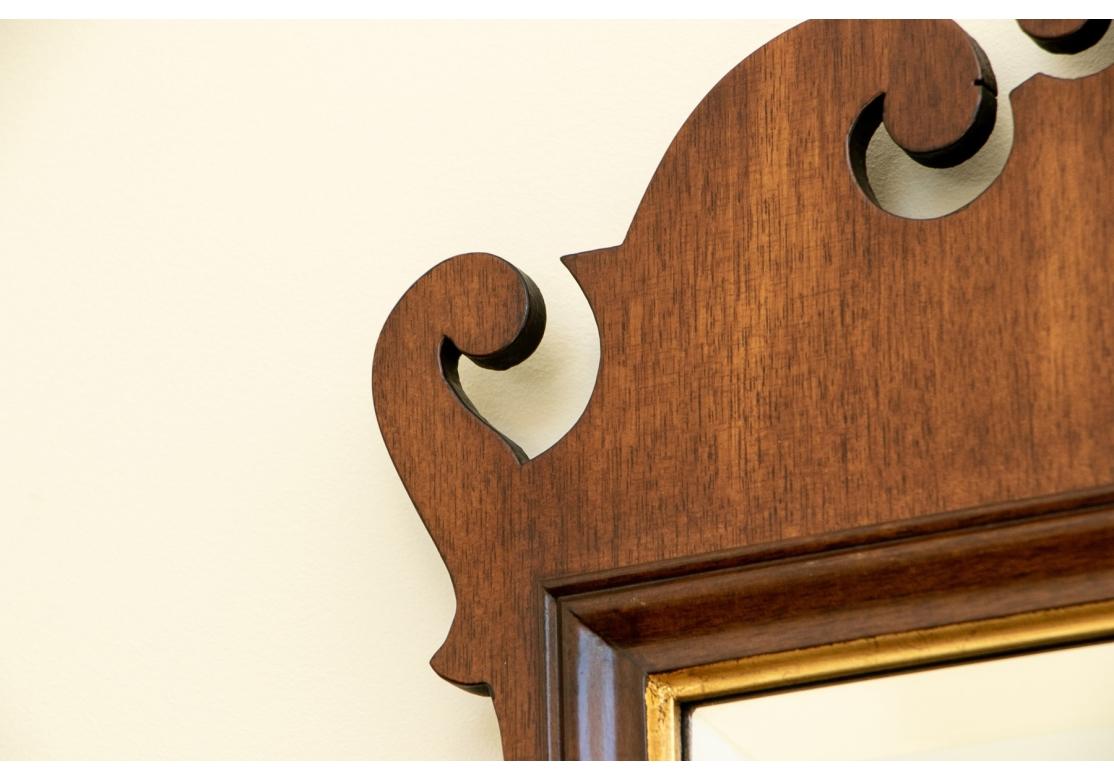 Classic Williamsburg mahogany chippendale style mirror with carved ears top and bottom, inner gilt surround, beveled glass. Bearing the original label on verso.

Dimensions: 
Frame - 40 5/8