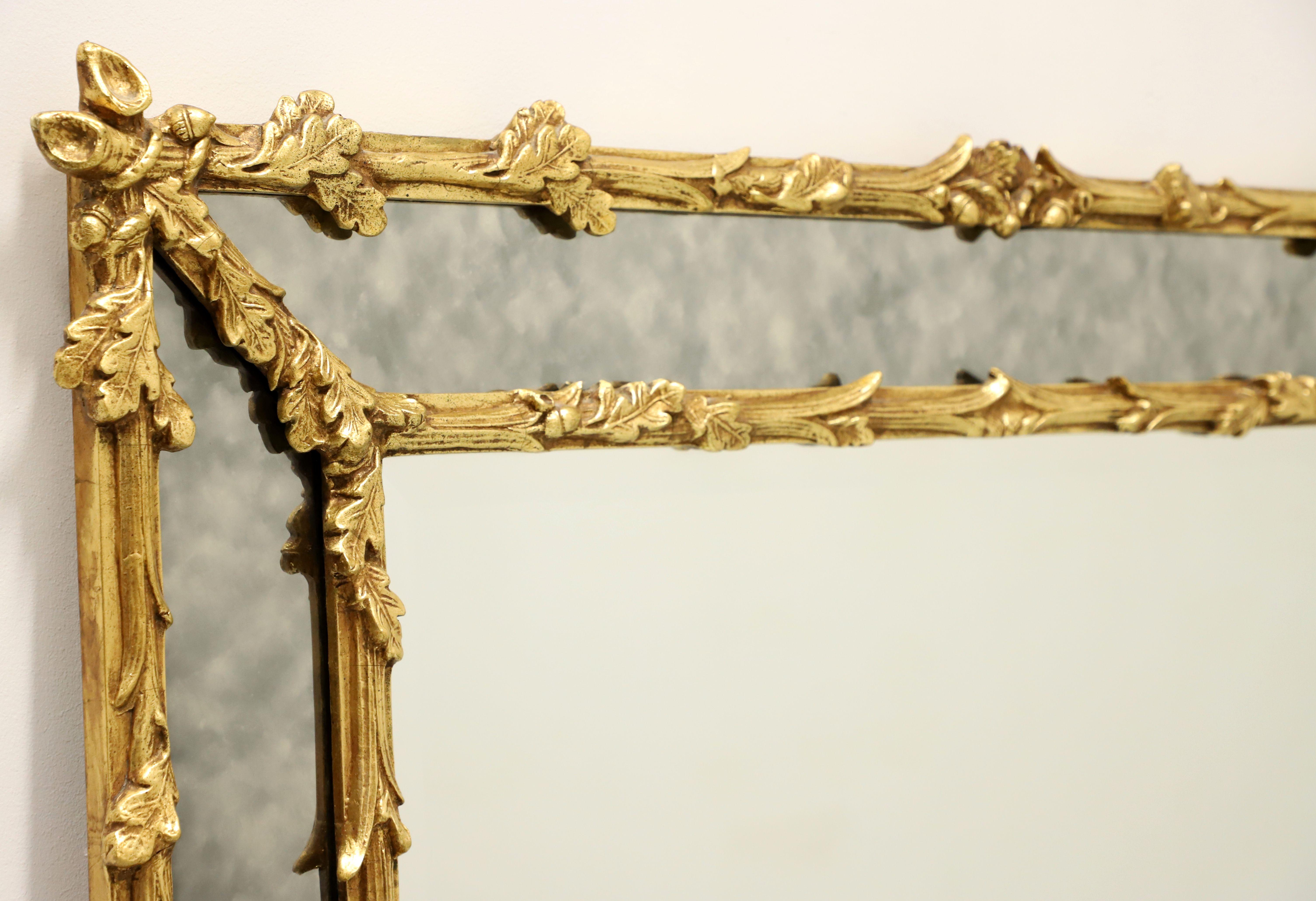 A parclose wall mirror in the French style by Friedman Brothers. Beveled mirror glass in an intricately carved gold gilt painted wood frame with large strips of smokey colored mirrors surrounding the outer edges. Features a foliate wood design,