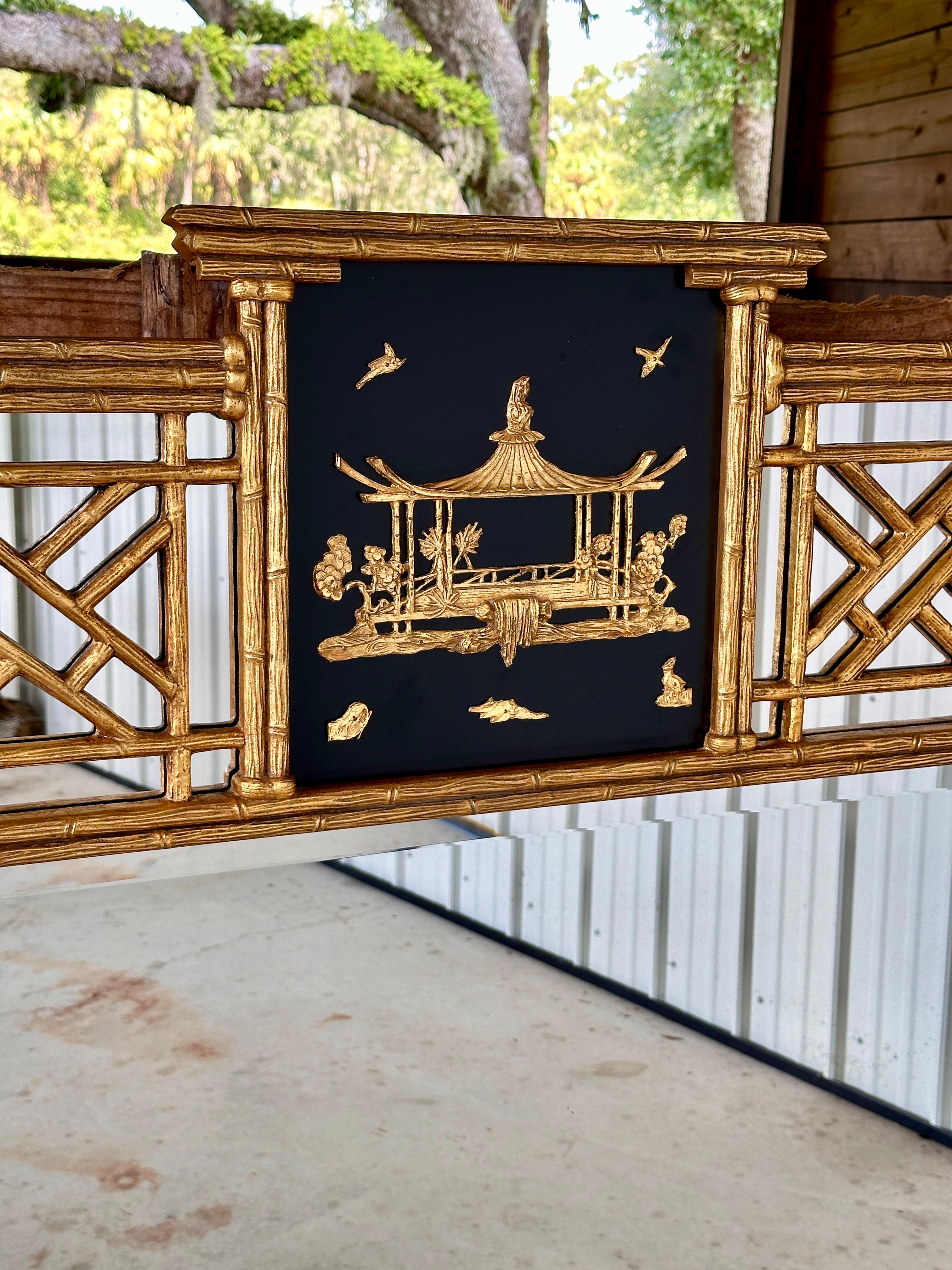 Mid-20th Century Friedman Brothers Chinoiserie Mirror, featuring a gilded faux bamboo frame with intricate fretwork and a captivating center panel.
The top section showcases a black lacquered background adorned with gold-toned relief, depicting a