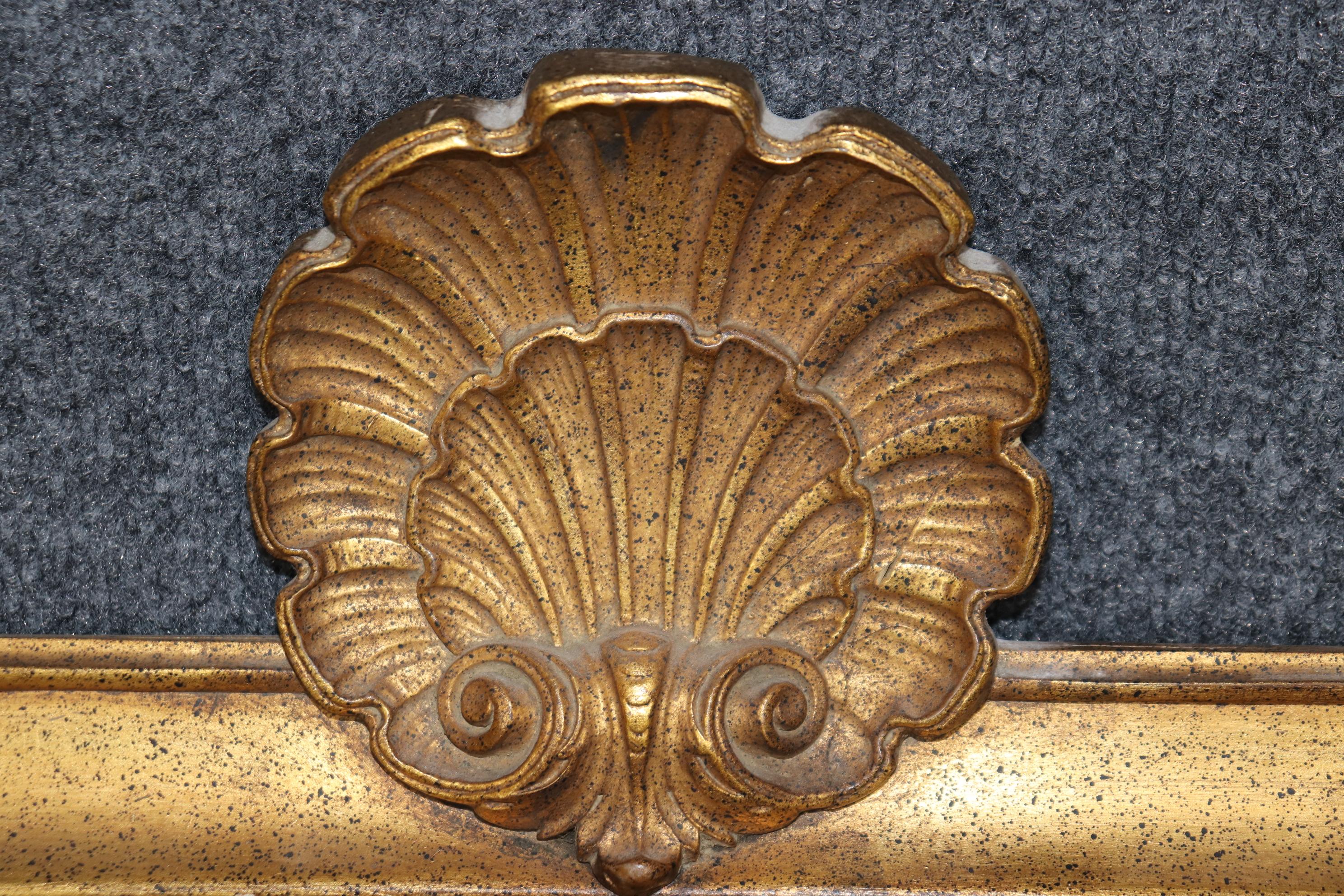 This is a gorgeous and simple Dorothy Draper era Hollywood Regency era giltwood mirror by Decorative Arts/Friedman Brothers of New York. Teh mirror features a gorgeous shell motif at the top its gilded frame and is delightfully sophisticated and
