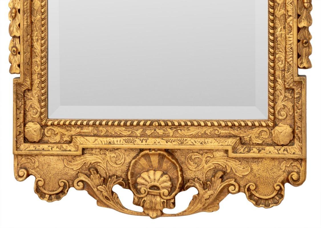 Friedman Brothers Georgian Style Giltwood Mirror, from the Colonial Williamsburg Collection, with crest form finial, shell, scroll, and acanthus leaf motif with beveled glass to center, paper label to the reverse.  51