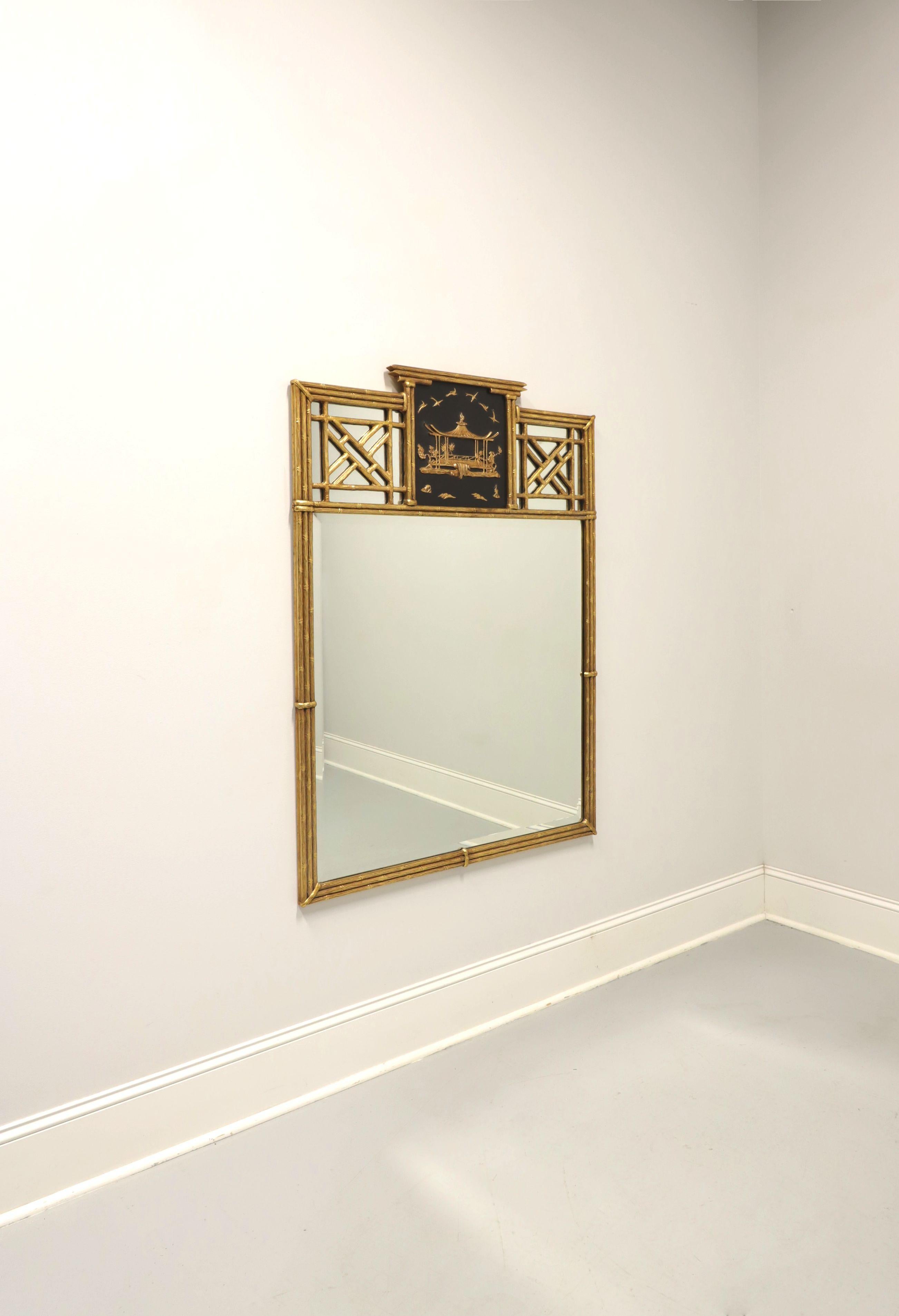 An Asian Japanese style wall mirror by Friedman Brothers. Beveled mirror glass in a rectangular shaped faux bamboo gold gilt painted frame with a top center panel of a floating golden pagoda & sea birds on a black background, and decorative faux