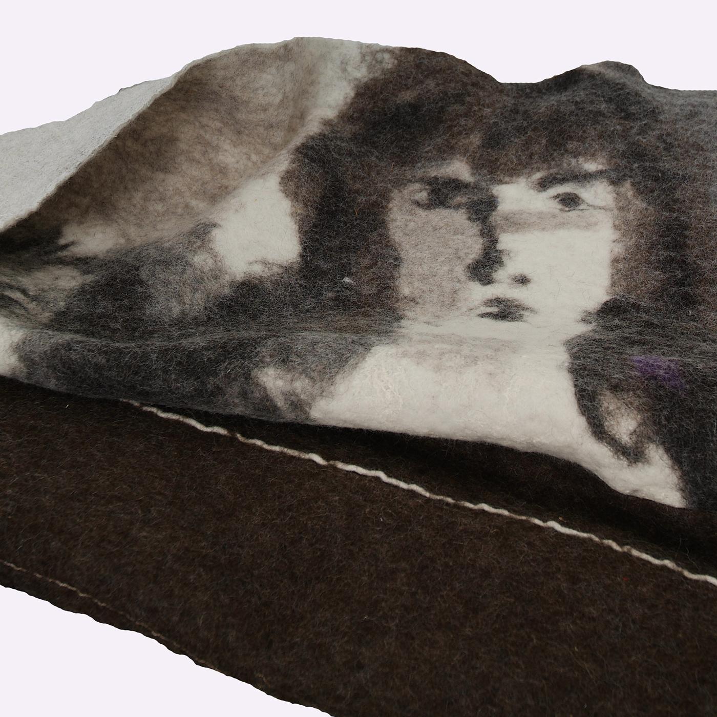This Friends blanket features an image of male faces. The nuno felting technique consists of massaging wool fibers by hand onto natural fabrics like cotton, silk and hemp linen with water and soap. As it is difficult to control this method, the