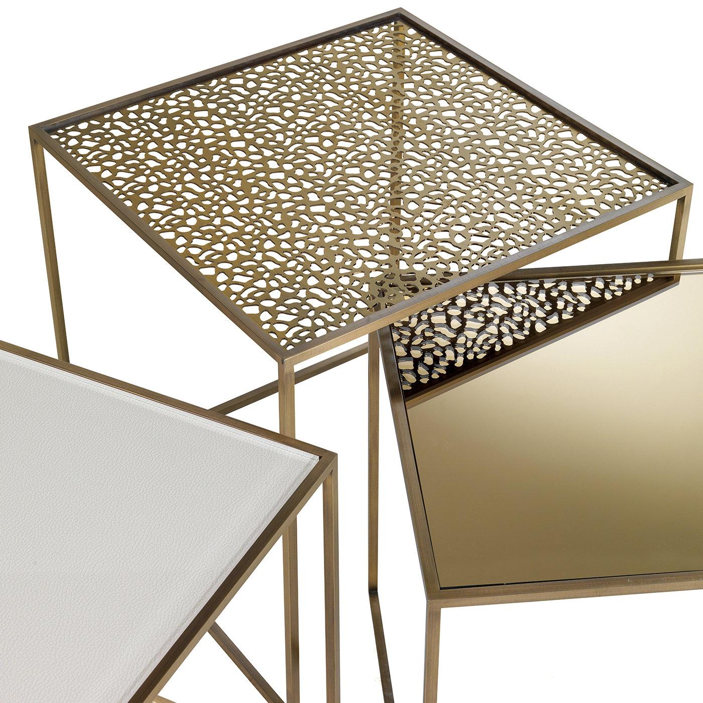 Part of the Friends collection of side tables, this piece will be an exquisite addition to a contemporary living room. Its square structure is made entirely of brass and comprises a base on three sides that supports a fretwork top. The irregular,