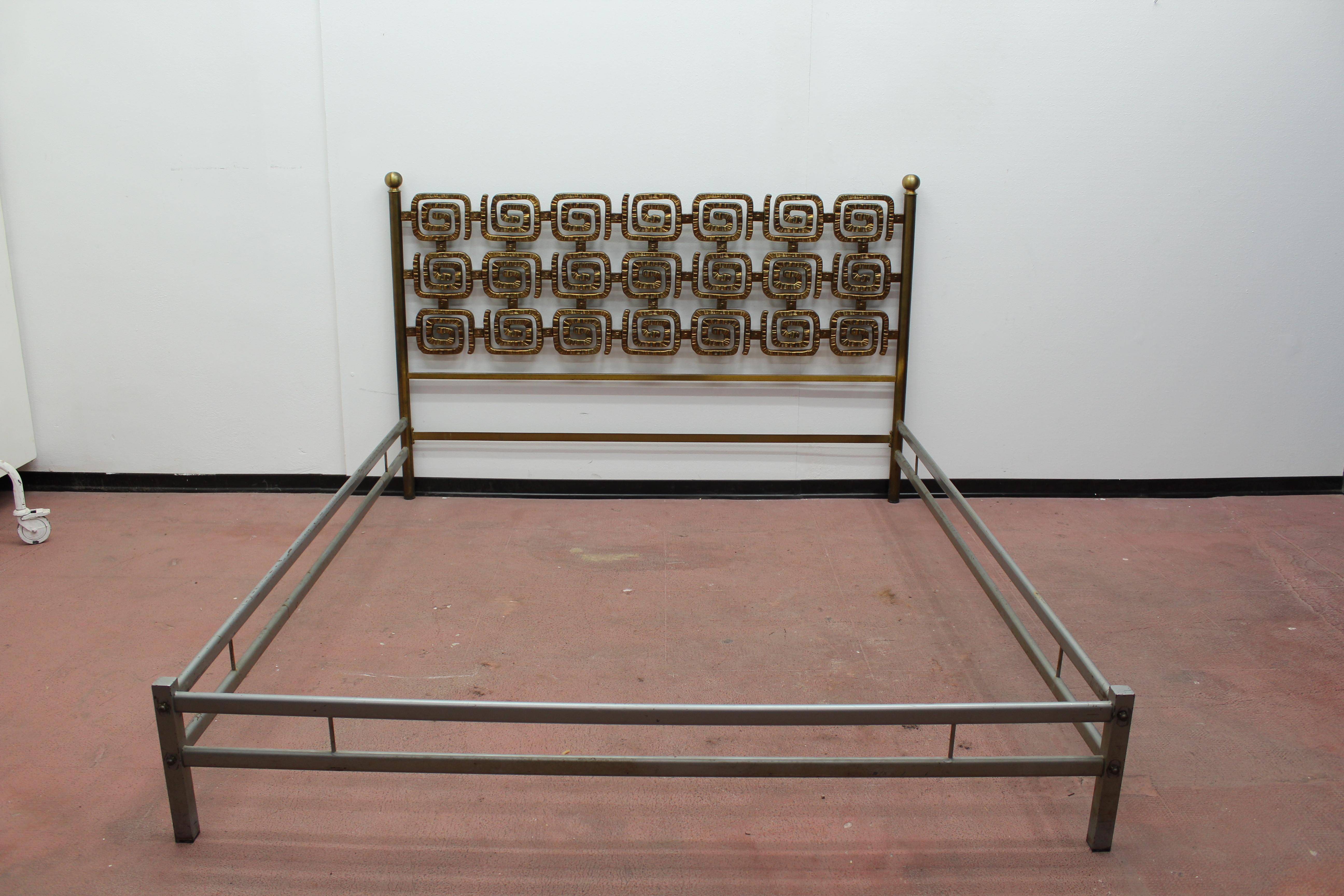 Beautifully crafted brass double bed by Italian artist Luciano Frigerio. The headboard and foot rail feature a wonderful heavy brass sculptural form interlocking loop motif with incised detailing in excellent condition. 
Wear consistent with age