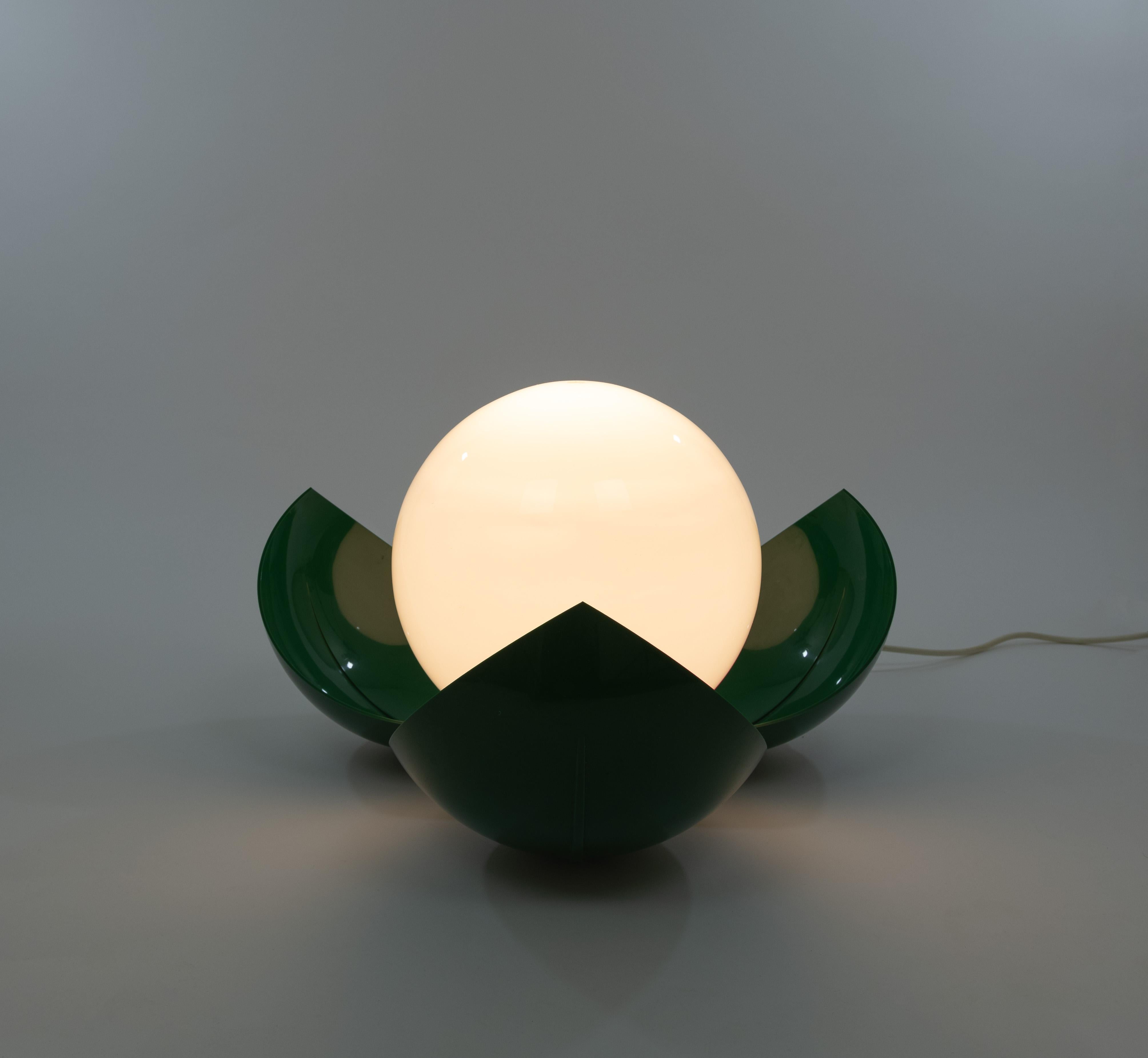 Lámpara de mesa Frine, de Studio Tetrarch (compuesto por los diseñadores: Adelaide Bonati, Silvio Bonatti, Enrico De Munari y Carla Federspiel) para Artemide, en 1968.

La lámpara consta de tres pantallas de solapa de plástico que parecen pétalos de
