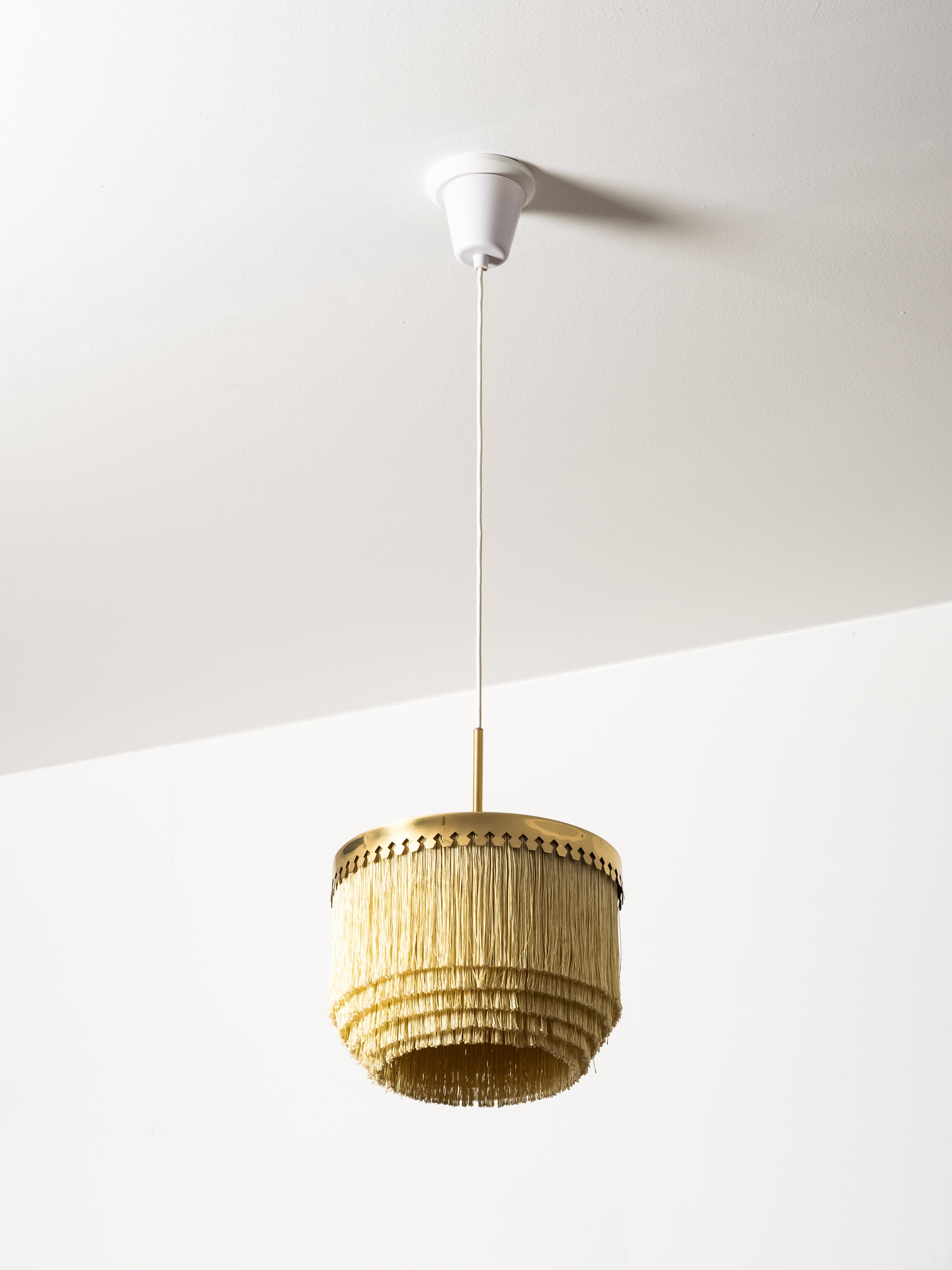 Original ‘T601/M’ ceiling lamp designed by Hans-Agne Jakobsson and produced by his company in Markaryd, Sweden, during the 1960s. This elegant model features Jakobsson’s distinctive multi-tiered champagne-colored textile fringe shade mounted on a