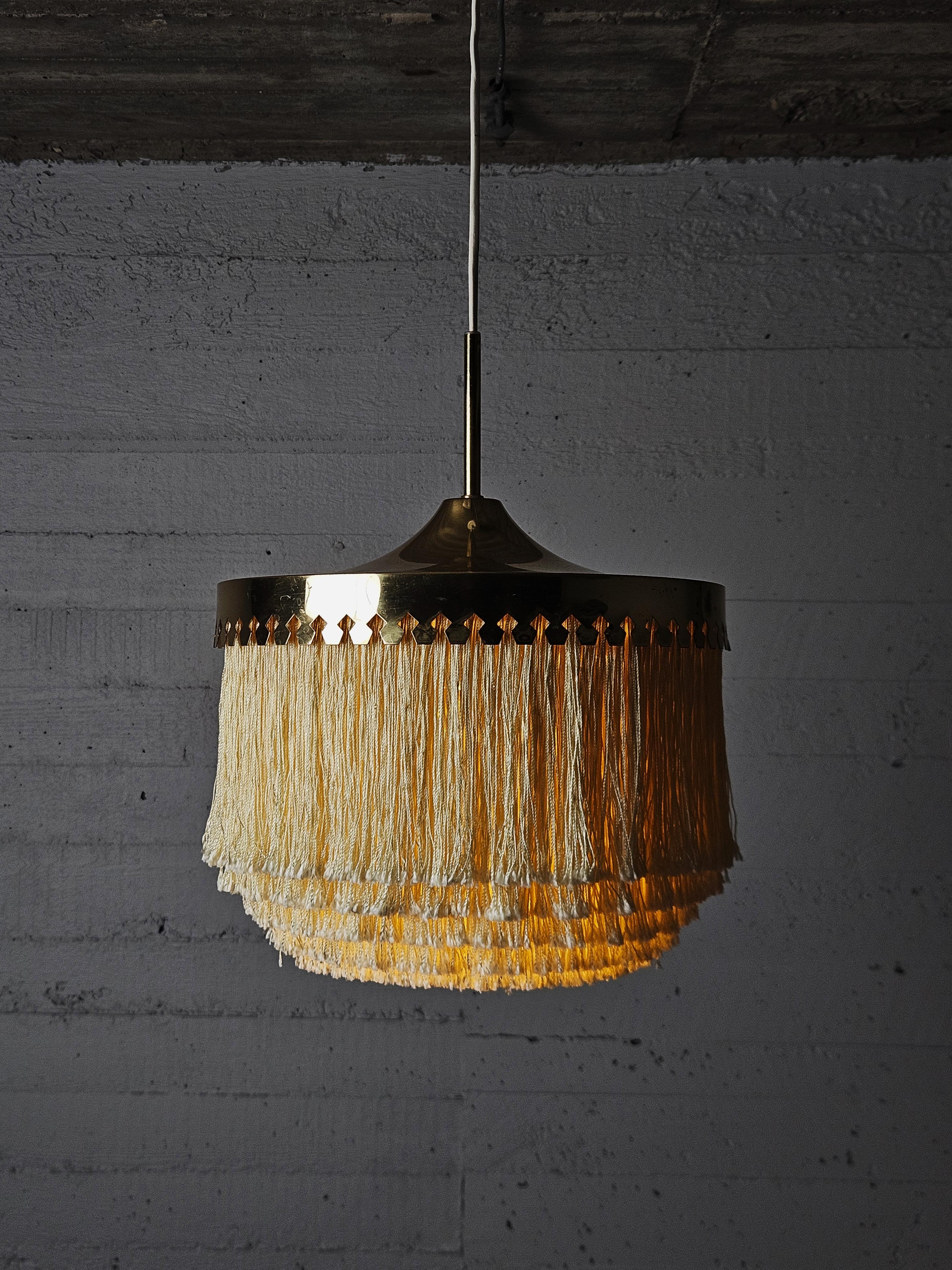 Elegant ceiling lamp model 'T601/M' designed by Hans-Agne Jakobsson for his own firm AB Markaryd, Sweden, during the 1960s. 

Champagne colored silk fringes hanging from the brass frame. 