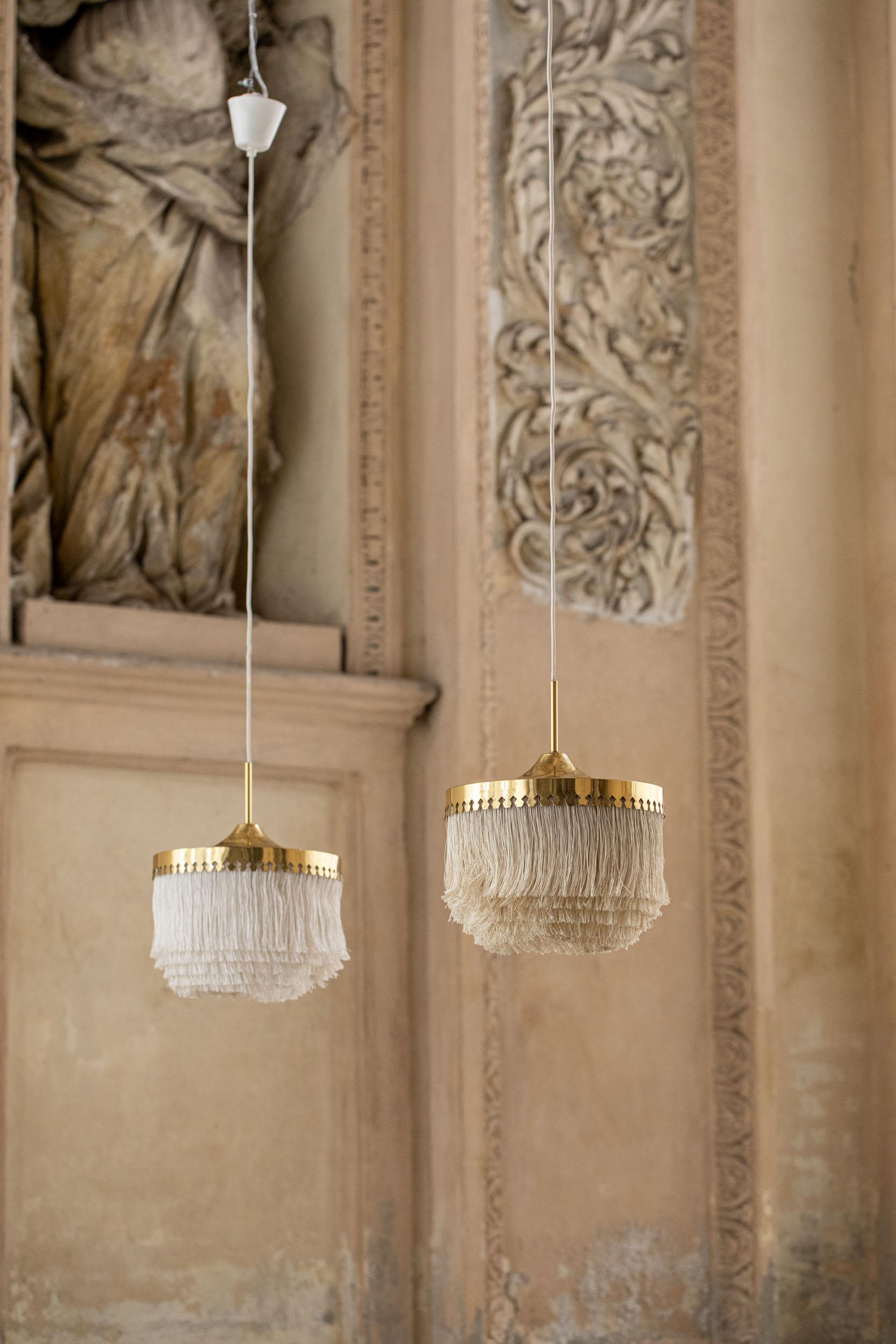 Elegant pair of fringe pendants lights by Hans Agne Jakobsson.
Beautiful fabric fringes in neutral color and gold brass decoration. 
Denmark 1950s.