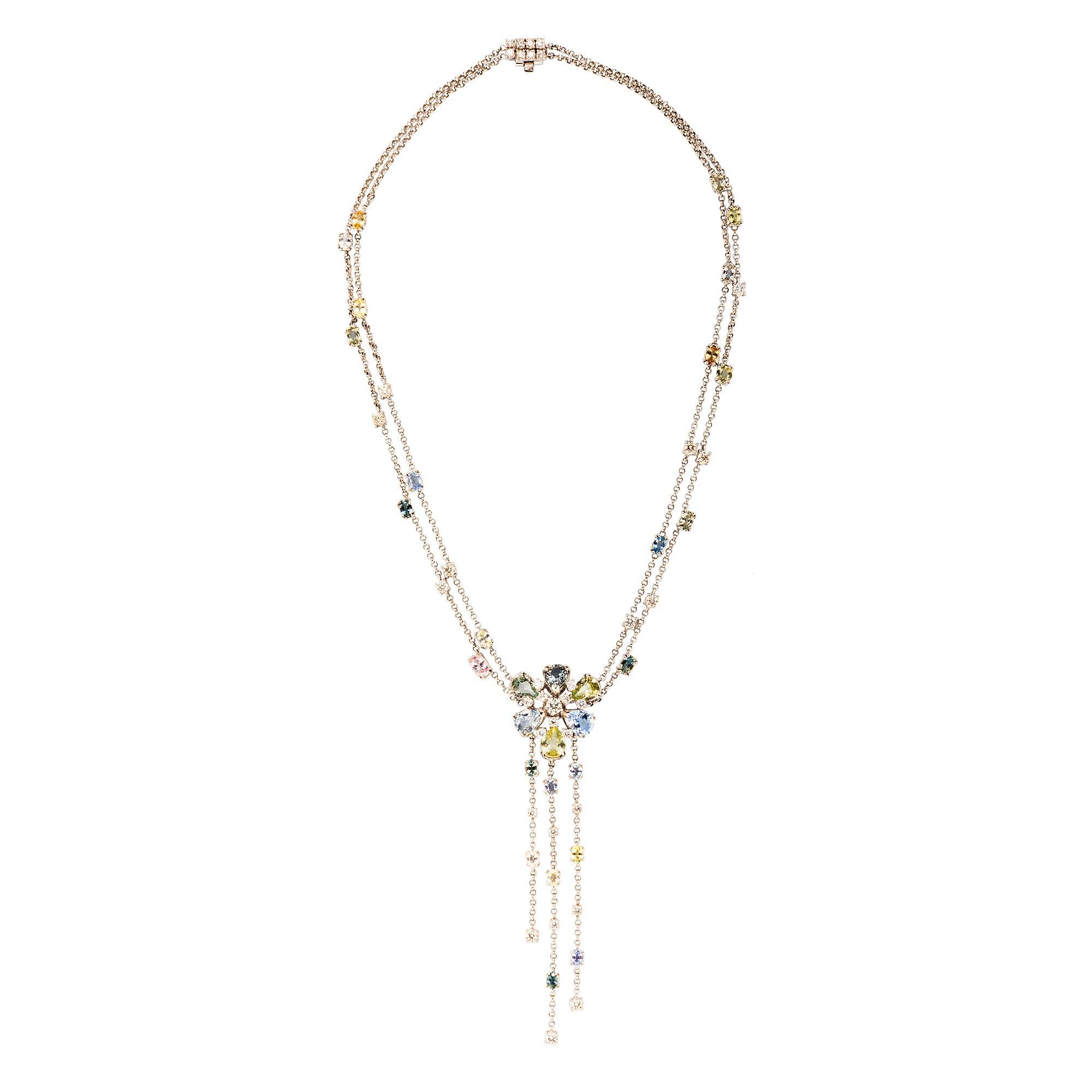 Two rows of cable link chain interspersed with pastel faceted oval sapphires and diamonds suspend a central flower made of pear-shaped pale green and purple sapphires. The flower design is accented by three rows of sapphire and diamond fringe.

-