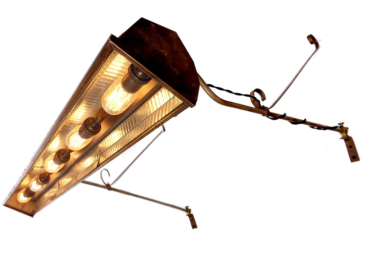 This is the type of early lamp that was used to light a large picture. It may also have served as to light a store sign or playhouse poster board. The lamp takes 5 bulbs, is 42 inches long and has fluted mirrored glass reflectors inside. It hangs