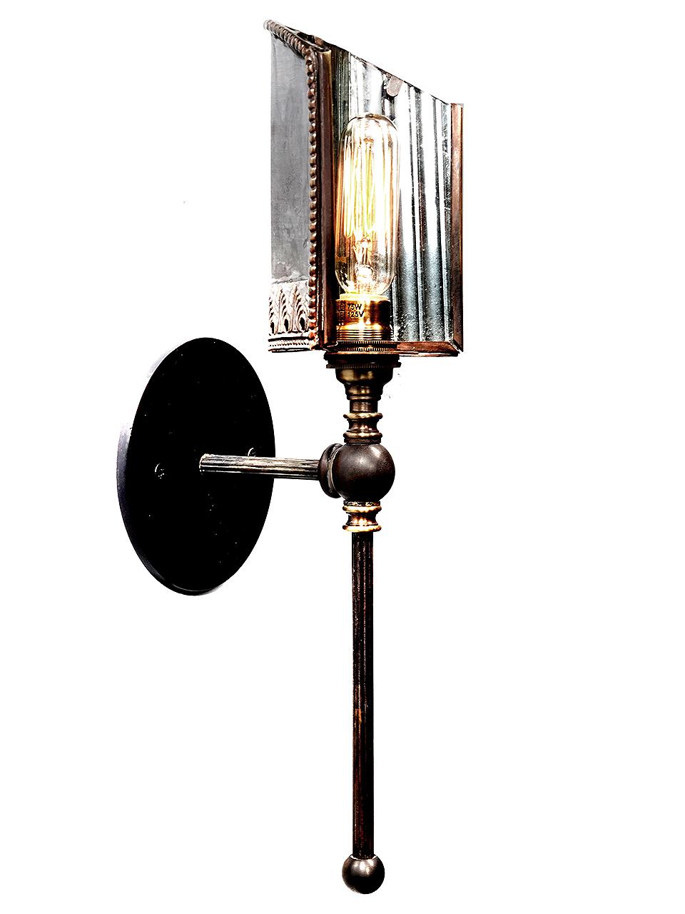 This is a rich looking sconce with out being too decorative. It has a simple and elegant. The shade has 3 fluted reflector mirrors often found on early 20th-Century lamps manufactured by the Frink Lighting Company. The brass shades also have a