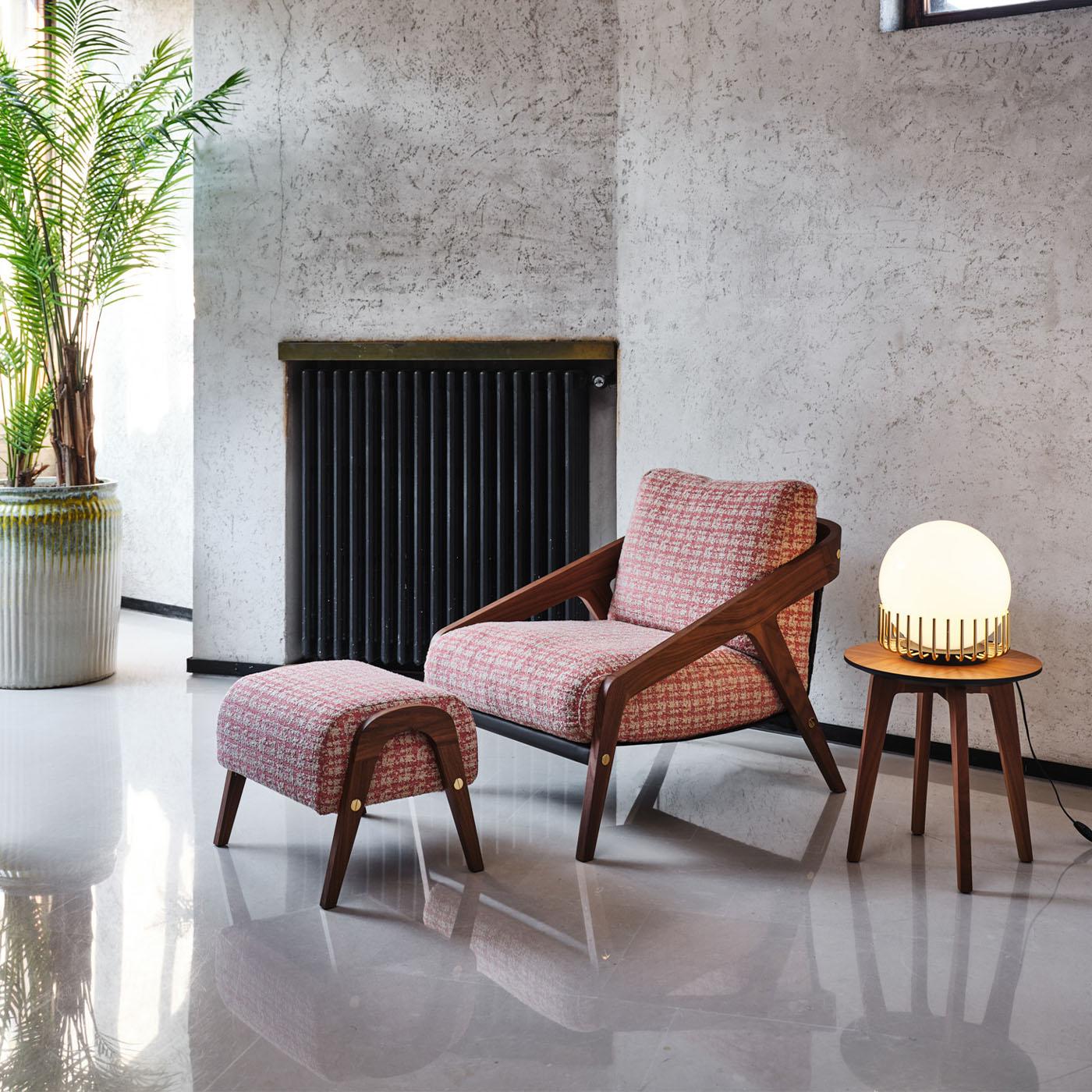 Dieser Sessel vereint die Persönlichkeit des Vintage-Stils mit der zeitlosen Anziehungskraft einer robusten Struktur aus Canaletto-Nussbaum. Das Gestell mit seinen dynamischen, abgeschrägten Profilen ist unter der Sitzfläche und an der Rückenlehne