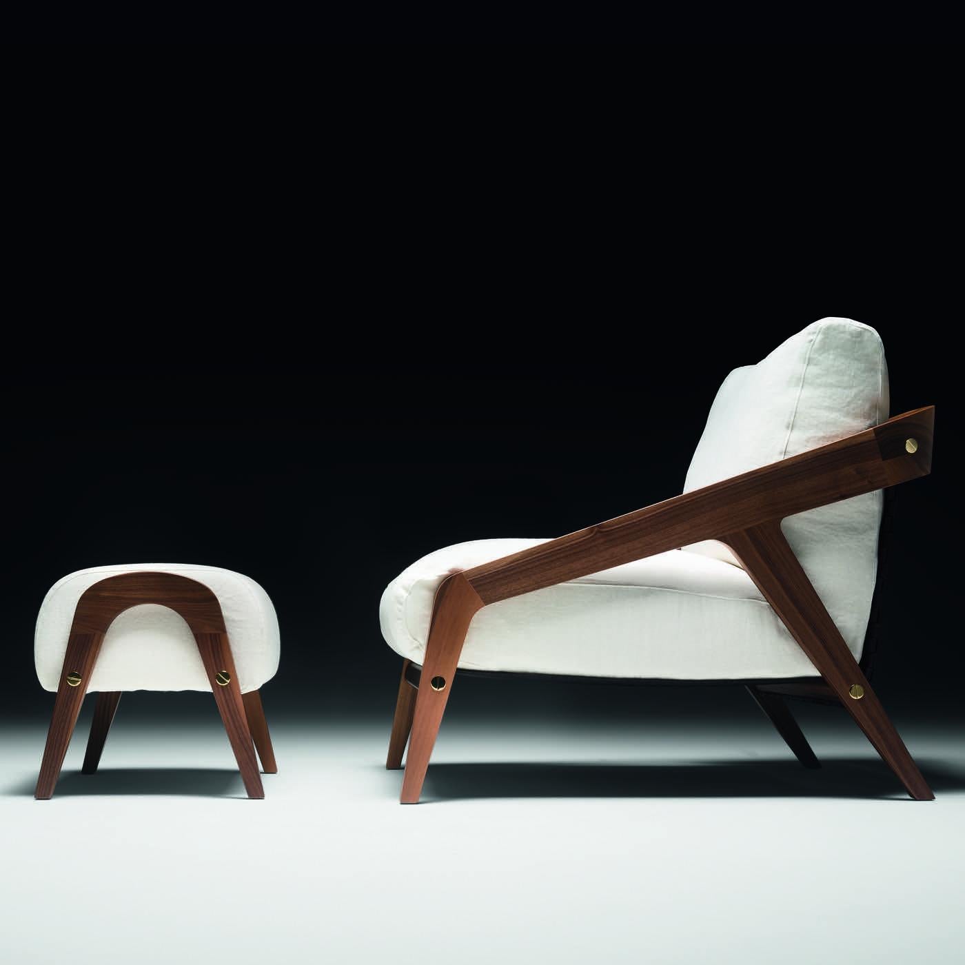 Les structures de cet ensemble exquis composé d'un fauteuil et d'un ottoman sont en noyer massif avec une finition à base d'eau. L'assise et le dossier de la chaise ainsi que le coussin de l'ottoman sont en plumes d'oie 100% européennes avec des
