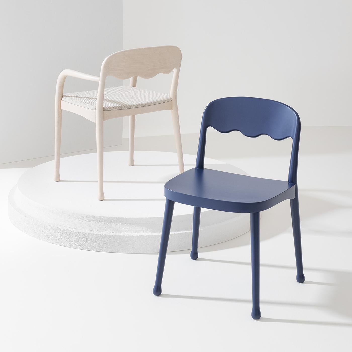 Simple yet elegant, this exquisite design by Cristina Celestino will add a lively and charming accent to a modern decor. Fashioned of solid beechwood with a matte blue finish, it features a large and welcoming seat embellished with a superb open and