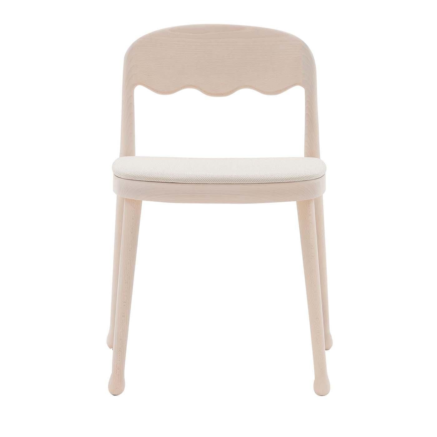 Showcasing a cream shade of white, this splendid chair is part of a series of wooden chairs designed by Cristina Celestino. Fashioned of ash wood, the piece rests on four slightly slanted legs completed with smooth, round feet equipped with felt
