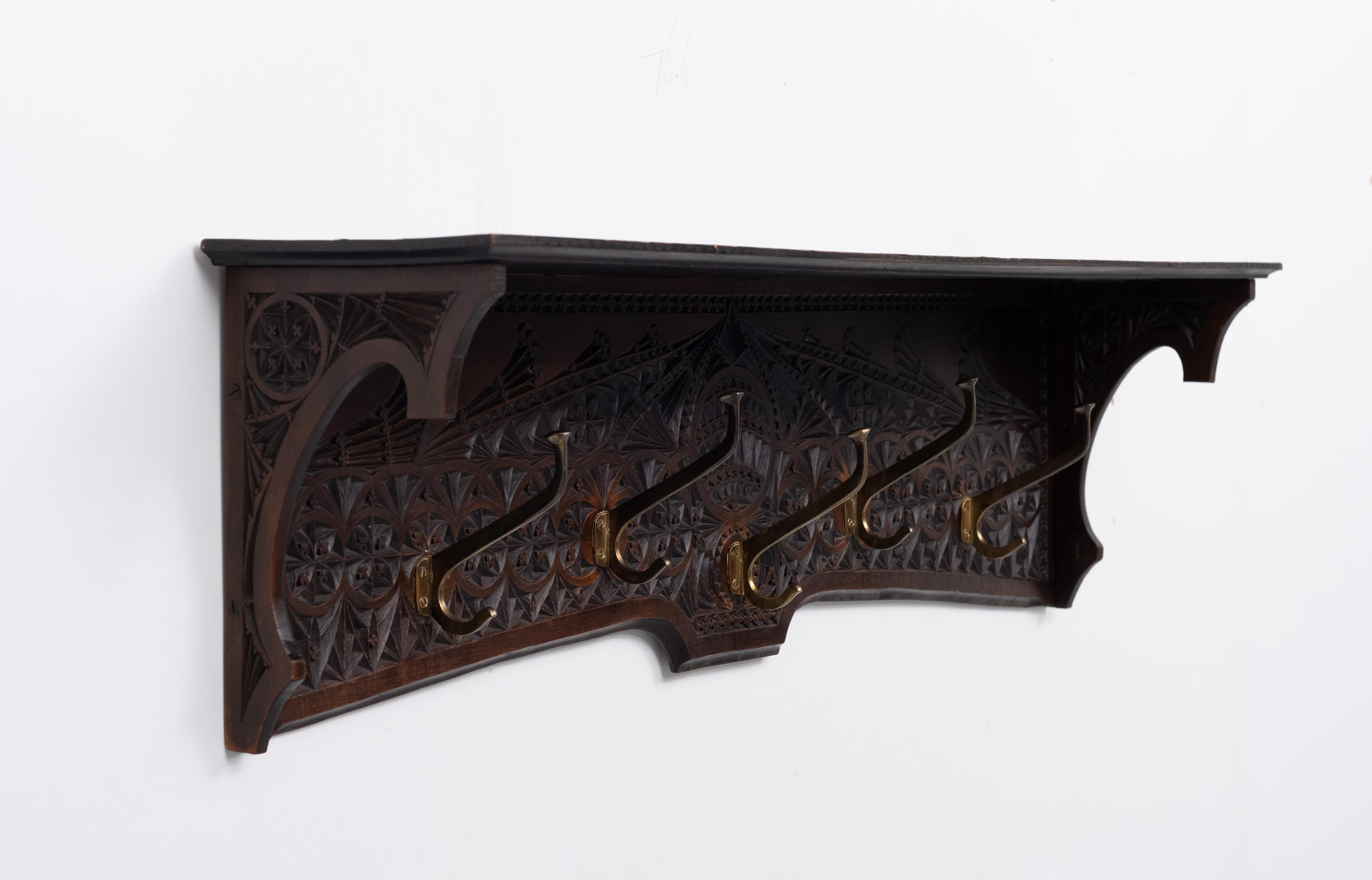 Frisian, antique, oak carved hanging coat rack. Typical geographical carving for the northern provinces off Holland. This style is existing for over 300 years 
This example is from the 1920s Hand carved Oak base, comes with 5 solid brass 
coat