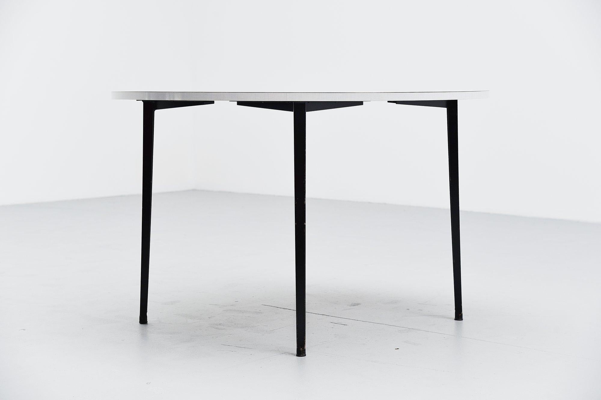 Rare round dining or working table designed by Friso Kramer for Ahrend de Cirkel, Holland, 1955. This table has a very nice light grey formica top and four black metal legs. This table has normal user wear along on the legs fits the industrial style