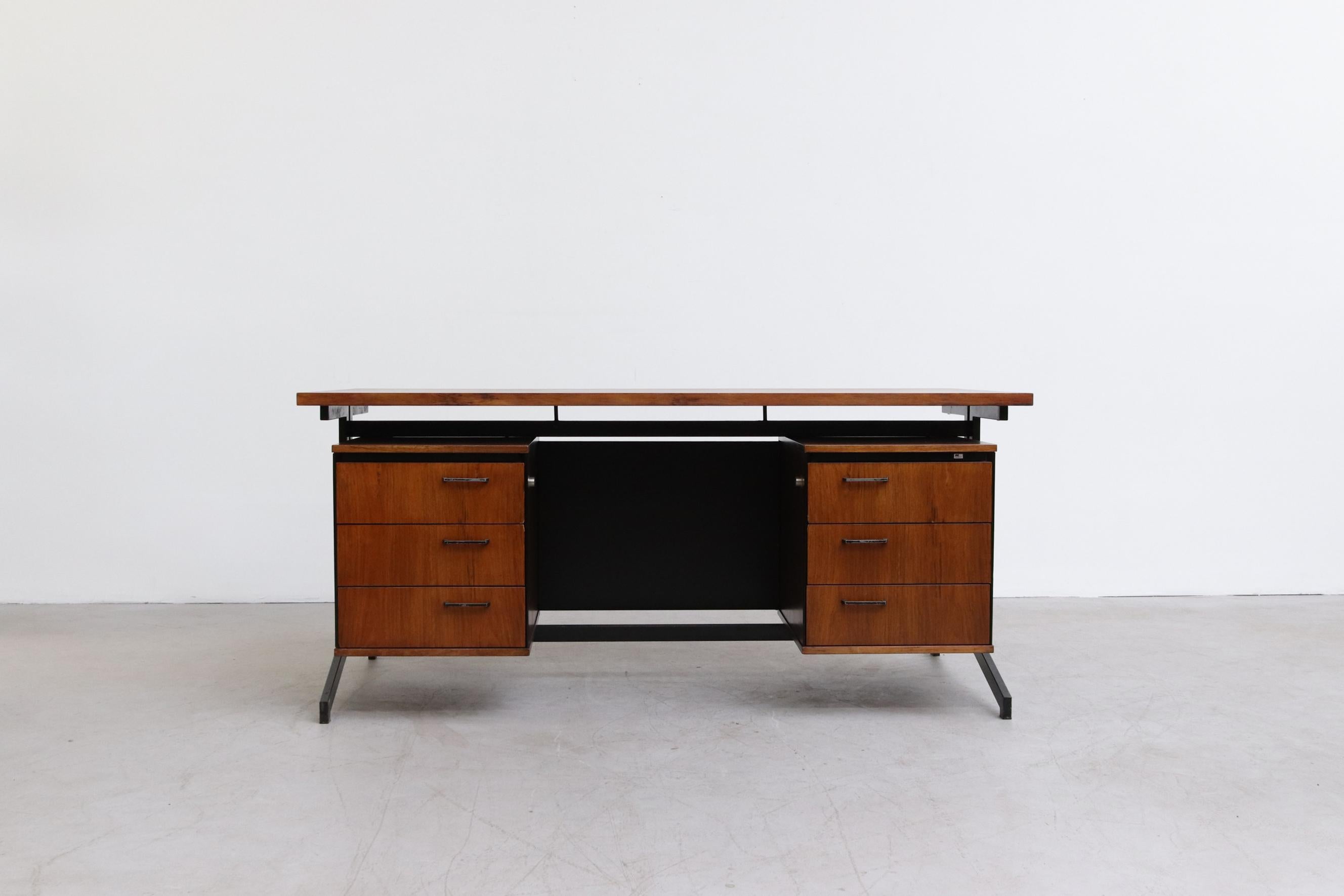 Rosewood executive desk with two sets of stacked drawers, a skai wrapped privacy screen and a floating rosewood top on a black enameled metal frame with prouve style legs. In original condition with visible wear and scratching. Leg opening is 24.5'.