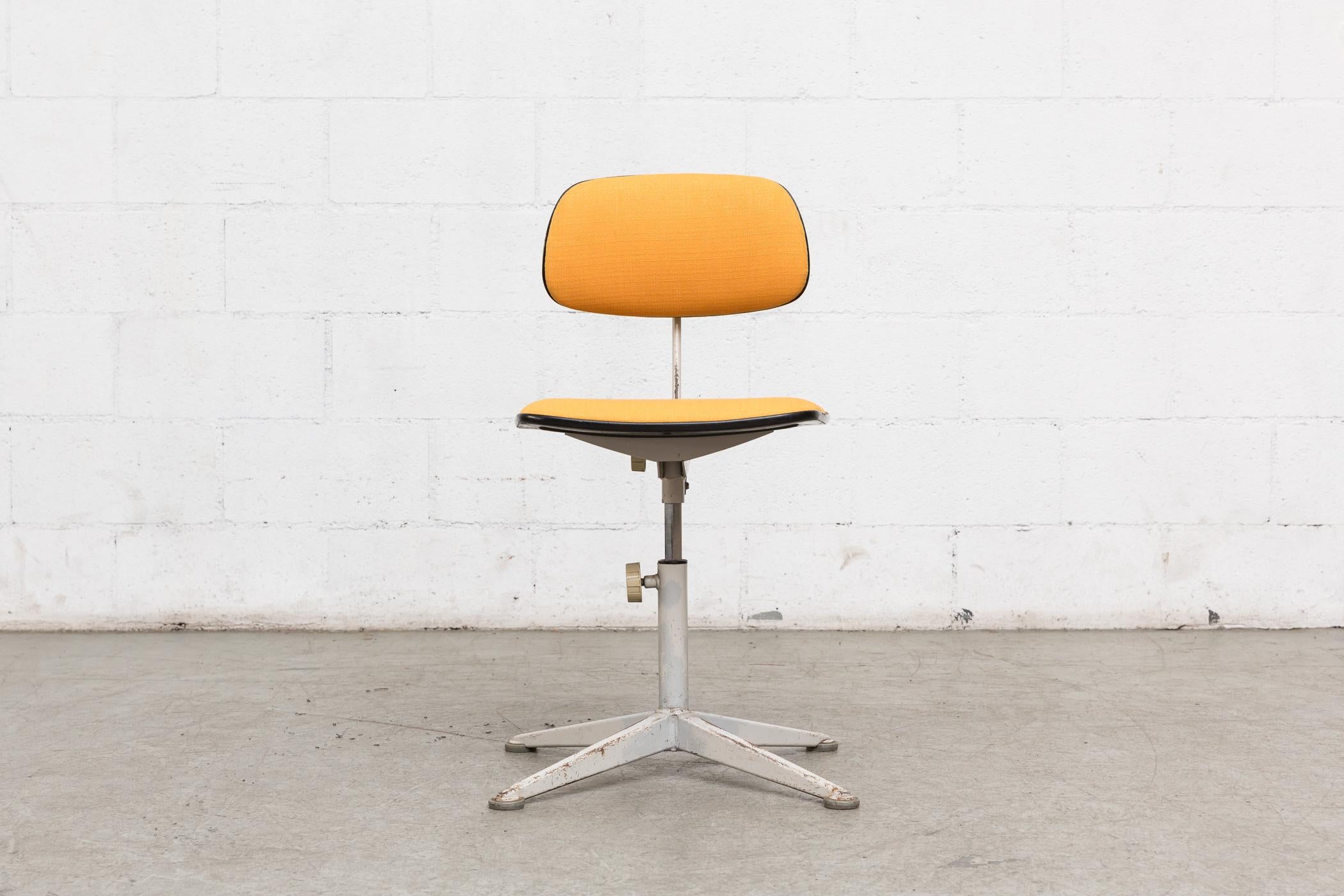 Friso Kramer drafting stool. Newly upholstered in mustard yellow with grey enameled steel frame. Adjustable seat and back height. Frame in original condition with visible wear for its age and usage.