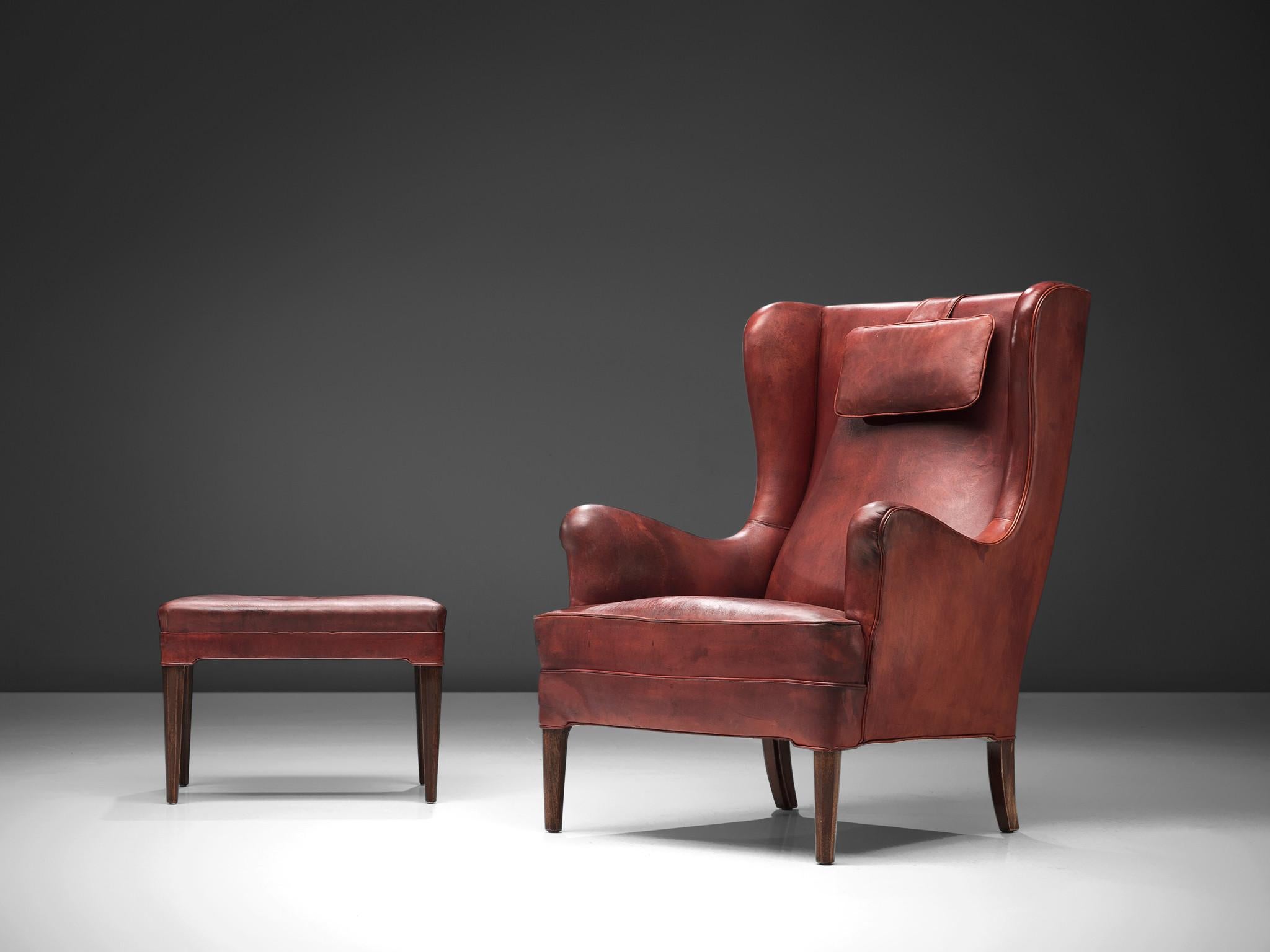 Frits Henningsen, wingback chair and ottoman, leather, wood, Denmark, 1940s.

Refined and timeless, the classical wingback chair by Frits Henningsen embodies elegance and comfort. Crafted with meticulous attention to detail, this chair, accompanied
