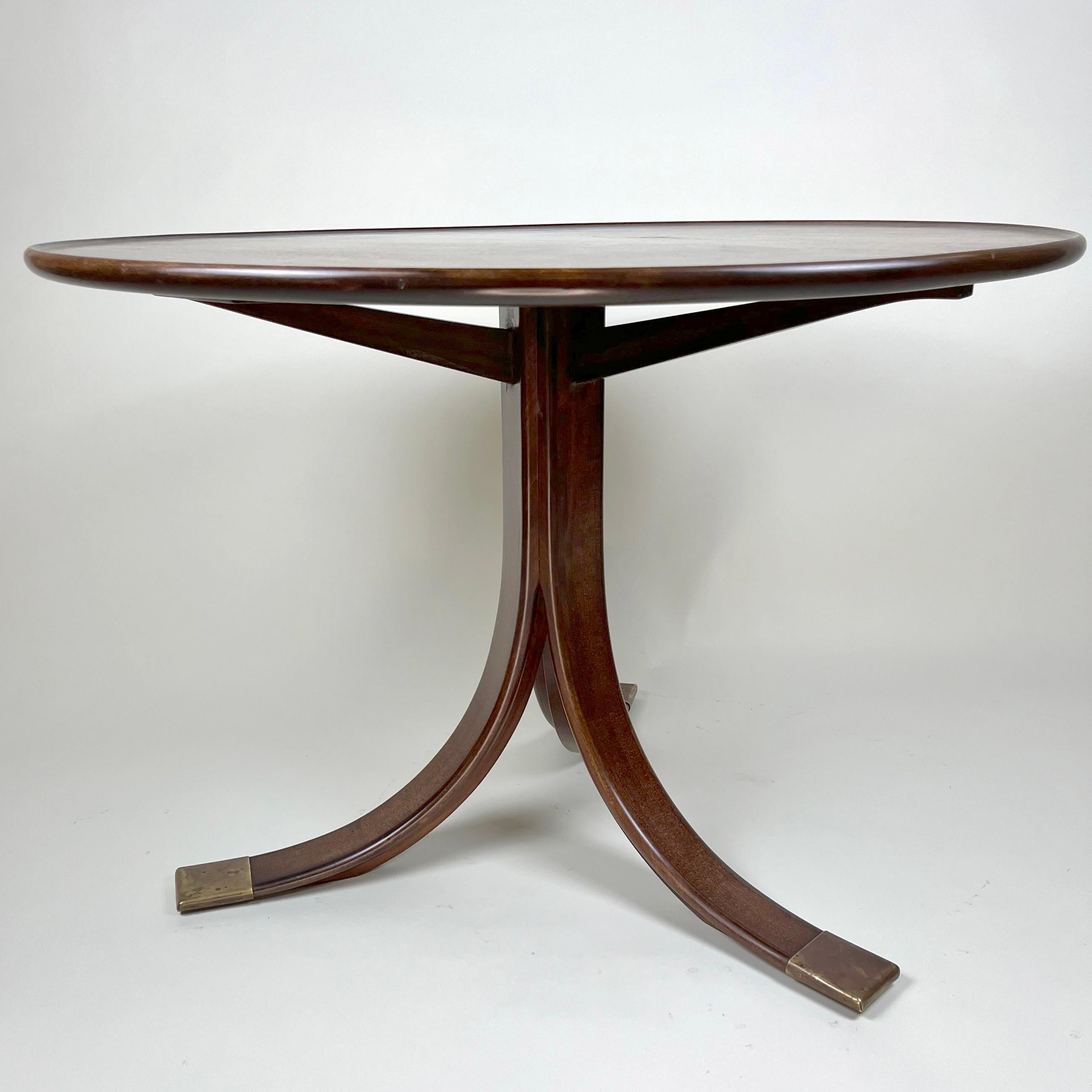 Frits Henningsen.
A Cuban mahogany circular Art Deco pedestal  table.
One-pillar frame with 3 spraying legs and brass ends. Top of solid wood with carved raised edge. Made circa 1930-39 by Frits Henningsen. Impressed “typical” order number to frame