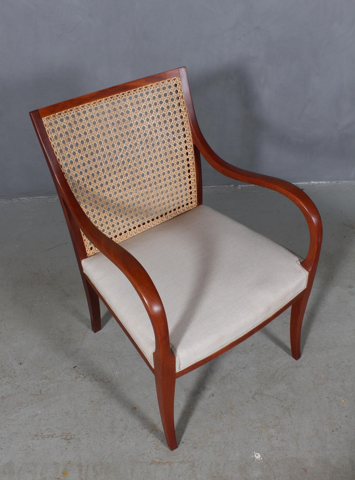 Frits Henningsen armchair. Frame of solid Cuba mahogany. Back with cane.

Seat later upholstered with light wool.

Designed in the 1930s, made by Frits Henningsen.
 
