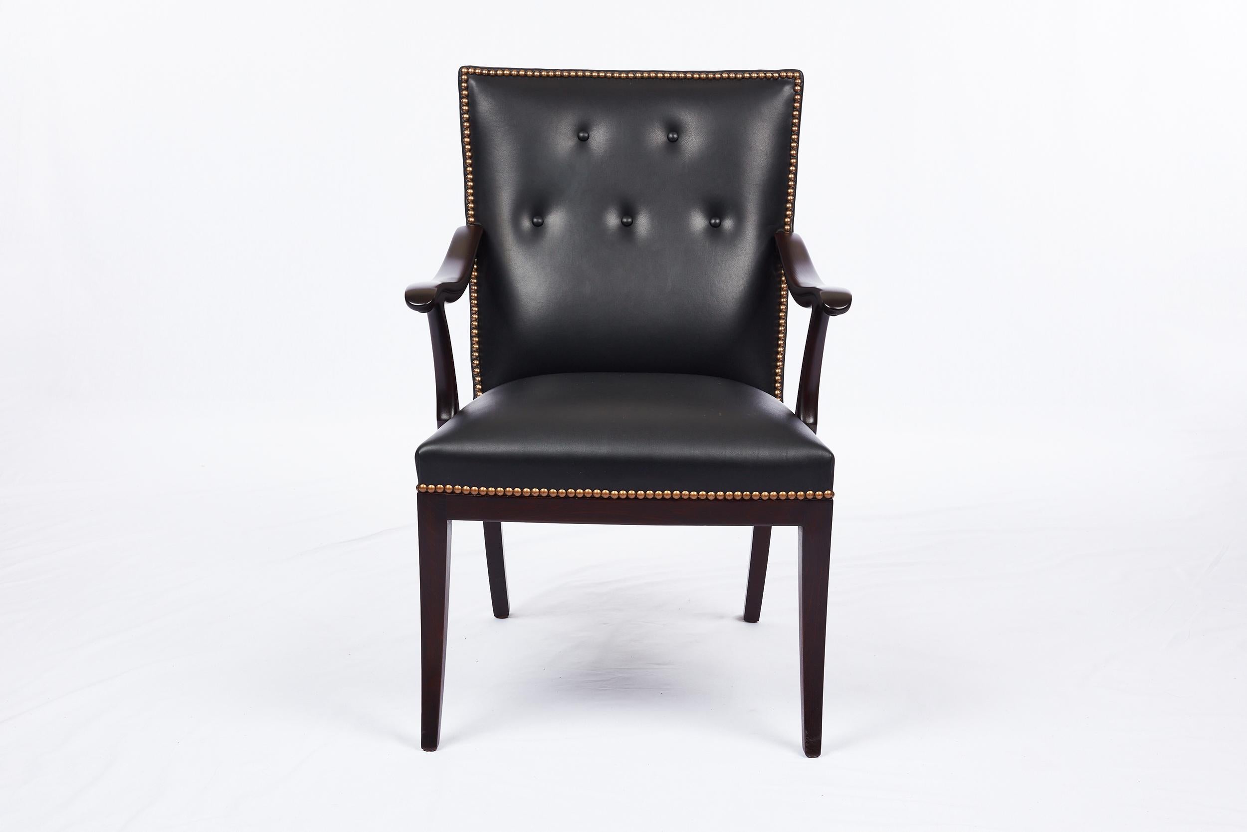 Frits Henningsen armchair. Designed in 1949. New black leather upholstery with brass nail heads.
