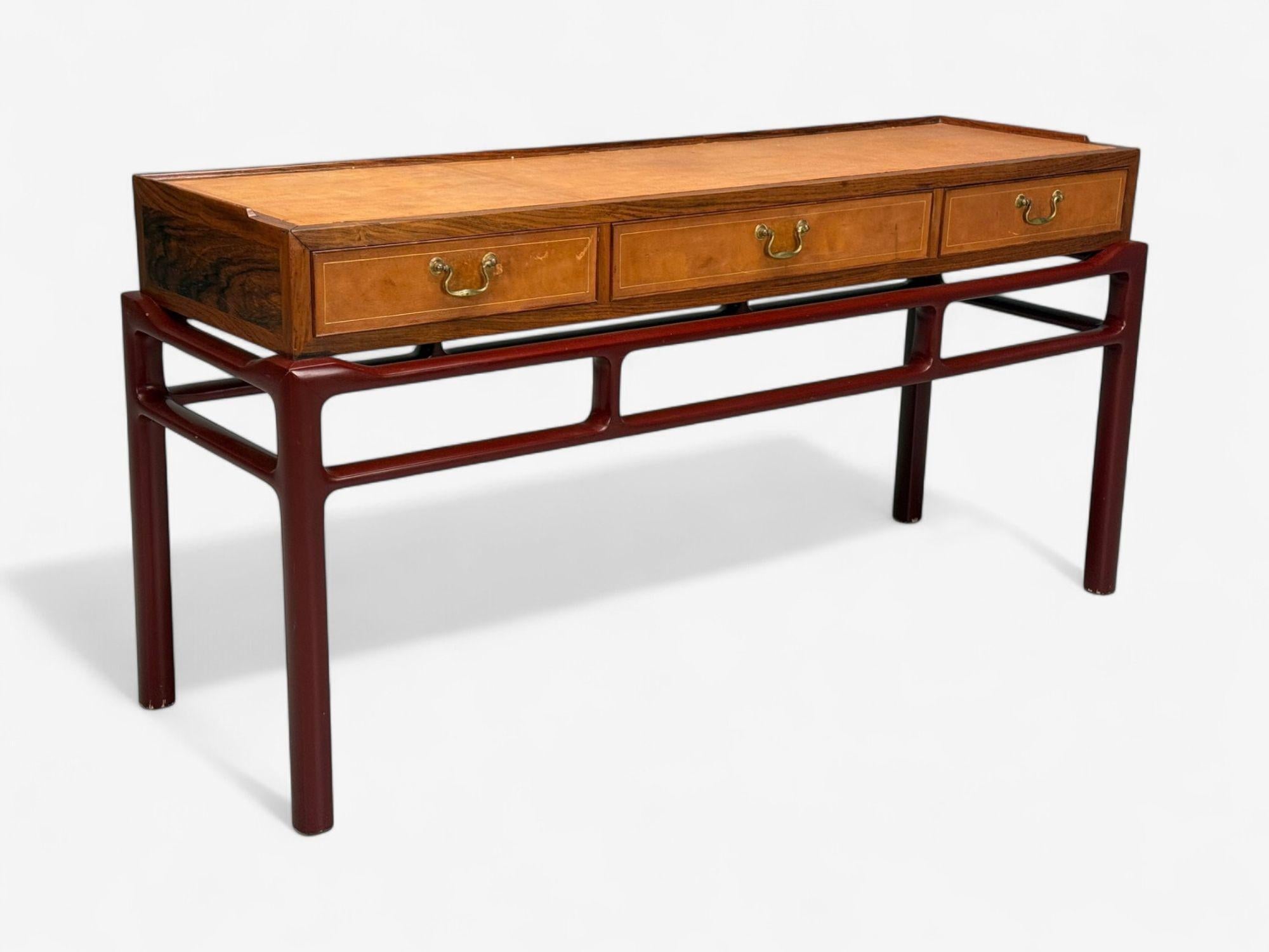 Frits Henningsen atr., Mesa consola danesa moderna de mediados de siglo, palisandro, cuero y latón, Dinamarca, años 50

Consola única de palisandro atribuida a Frits Henningsen y fabricada a mediados del siglo XX en Dinamarca. Este ejemplo tiene la