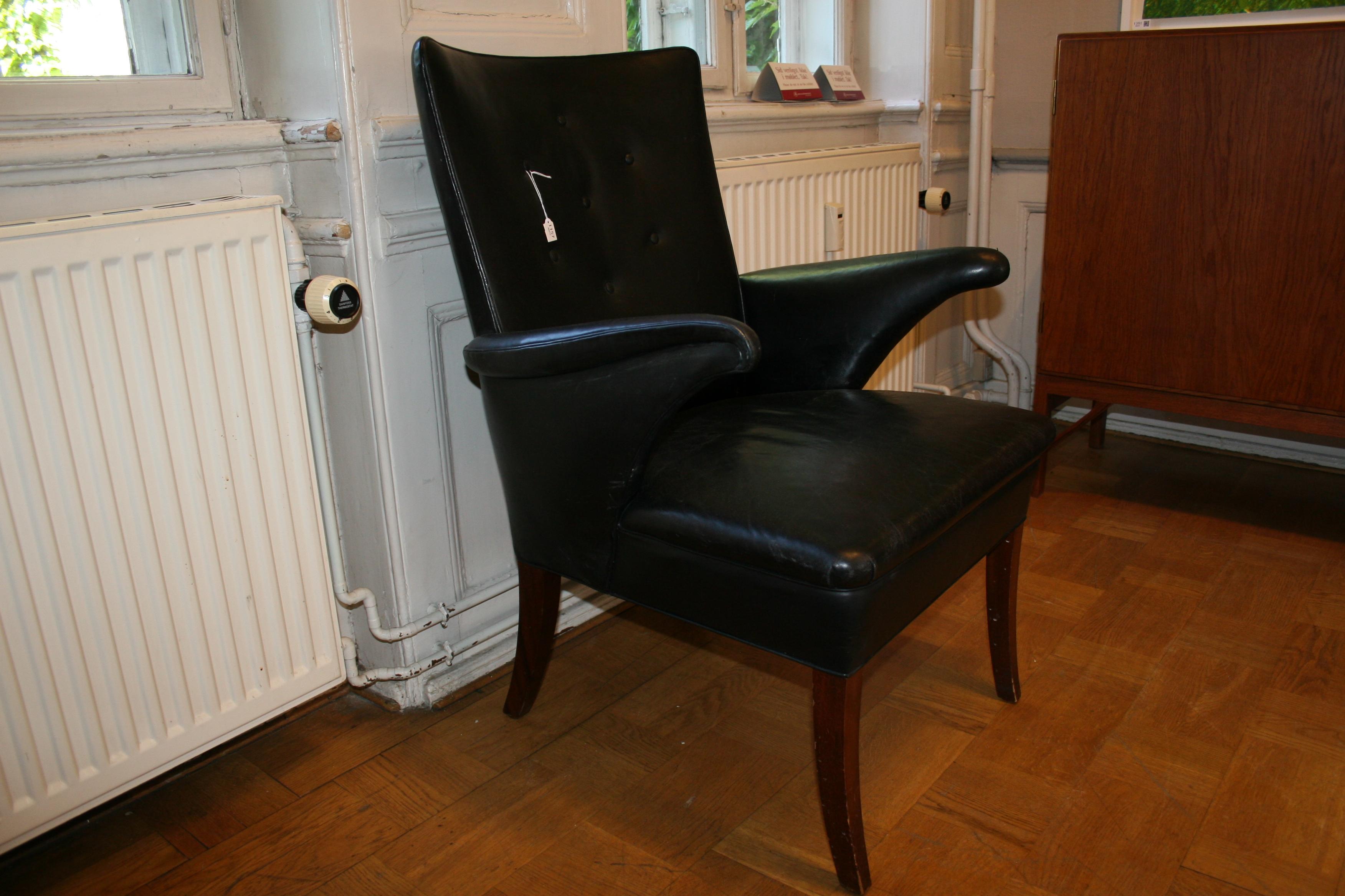 Dieser Sessel wurde in den 1940er oder 1950er Jahren vom Tischler Frits Henningsen entworfen und hergestellt. Das Leder  ist original und zeigt Patina, die auf das Alter schließen lässt. Die Keder an den Armlehnen in der Nähe der Handauflage sind an