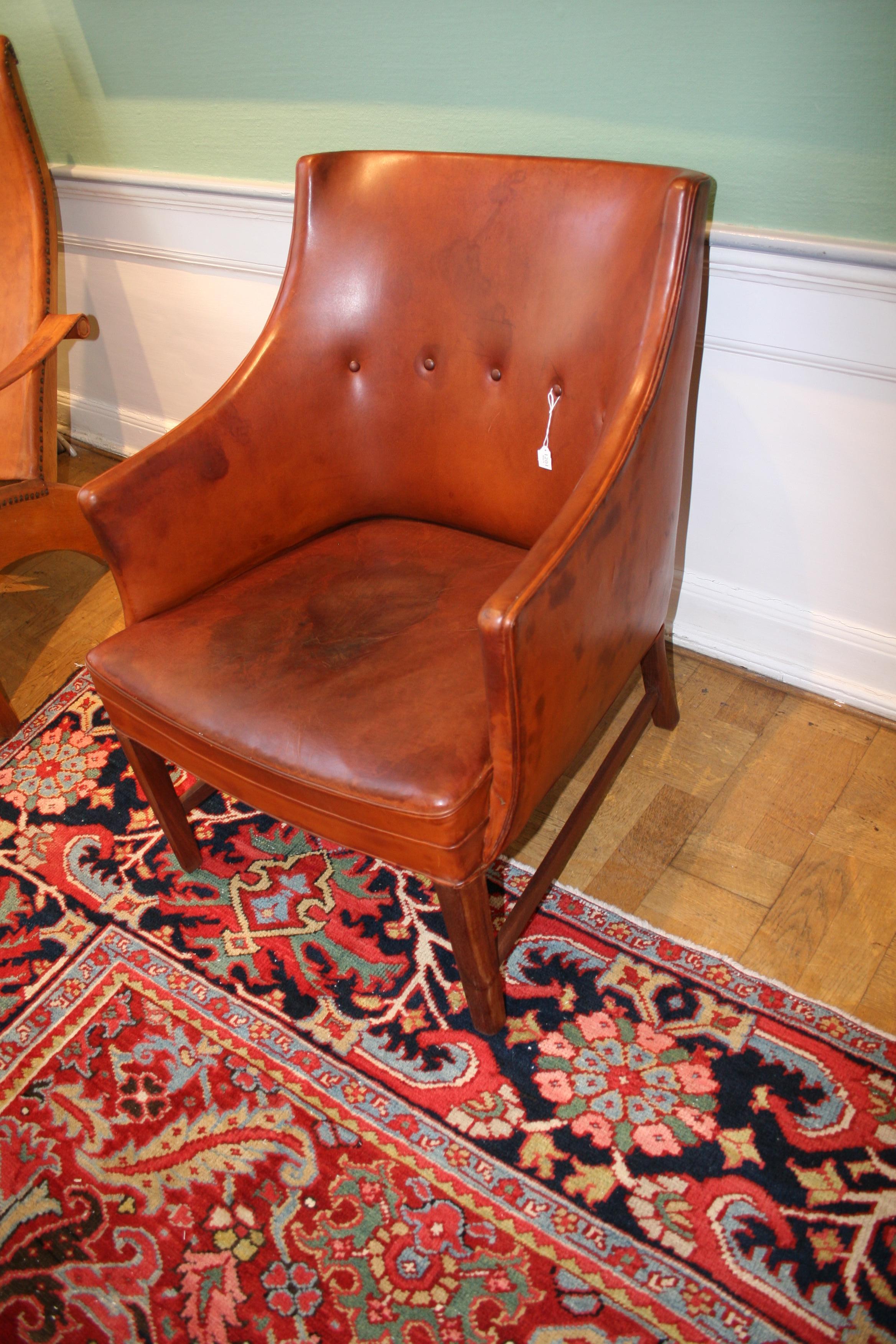 This cognac-color leather armchair is another of Frits Henningsen's iconic creations. With an original eye but a classical bent, Frits Henningsen created some of the most interesting designs from Denmark just before the Modern period for which