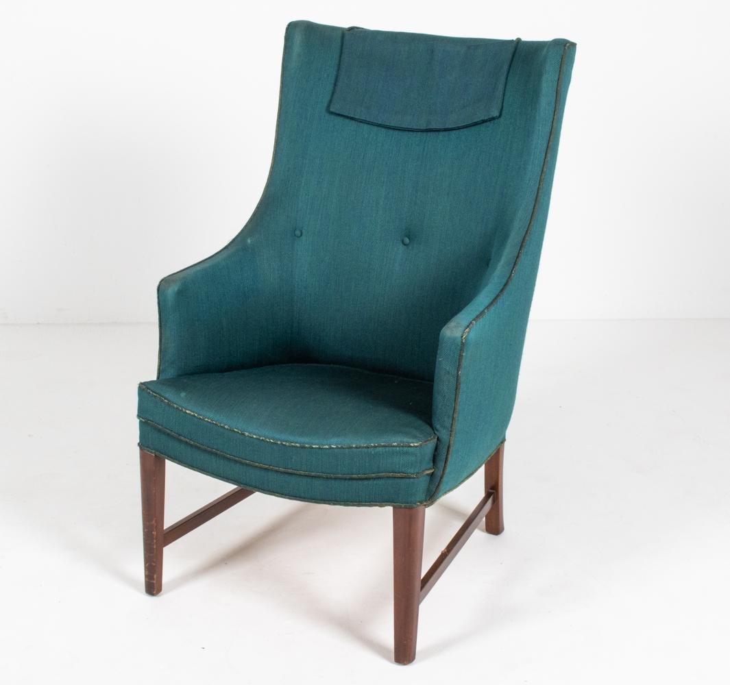 A handsome Danish mid-century high-back lounge chair, designed by furniture maker and designer Frits Henningsen (1889–1965), c. 1940's. Both the proprietor of a furniture-making workshop with a team of cabinetmakers in central Copenhagen as well as