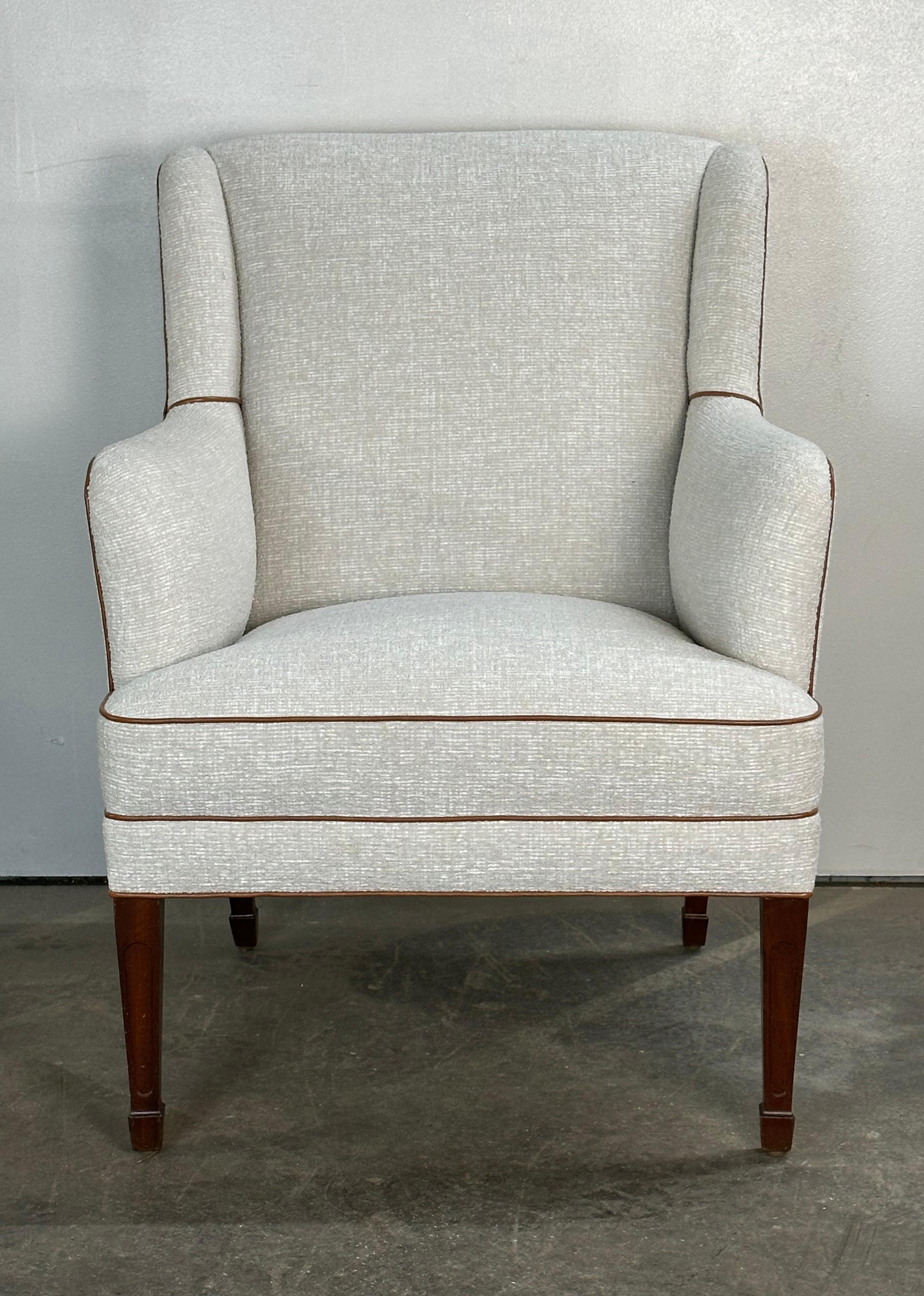 Frits Henningsen Danish modern lounge chair. Tastefully reupholstered in grey heather textile with cinnamon accented piping. Solid mahogany legs retain original finish and appearance. Very comfortable for reading or watching television. Elegant and