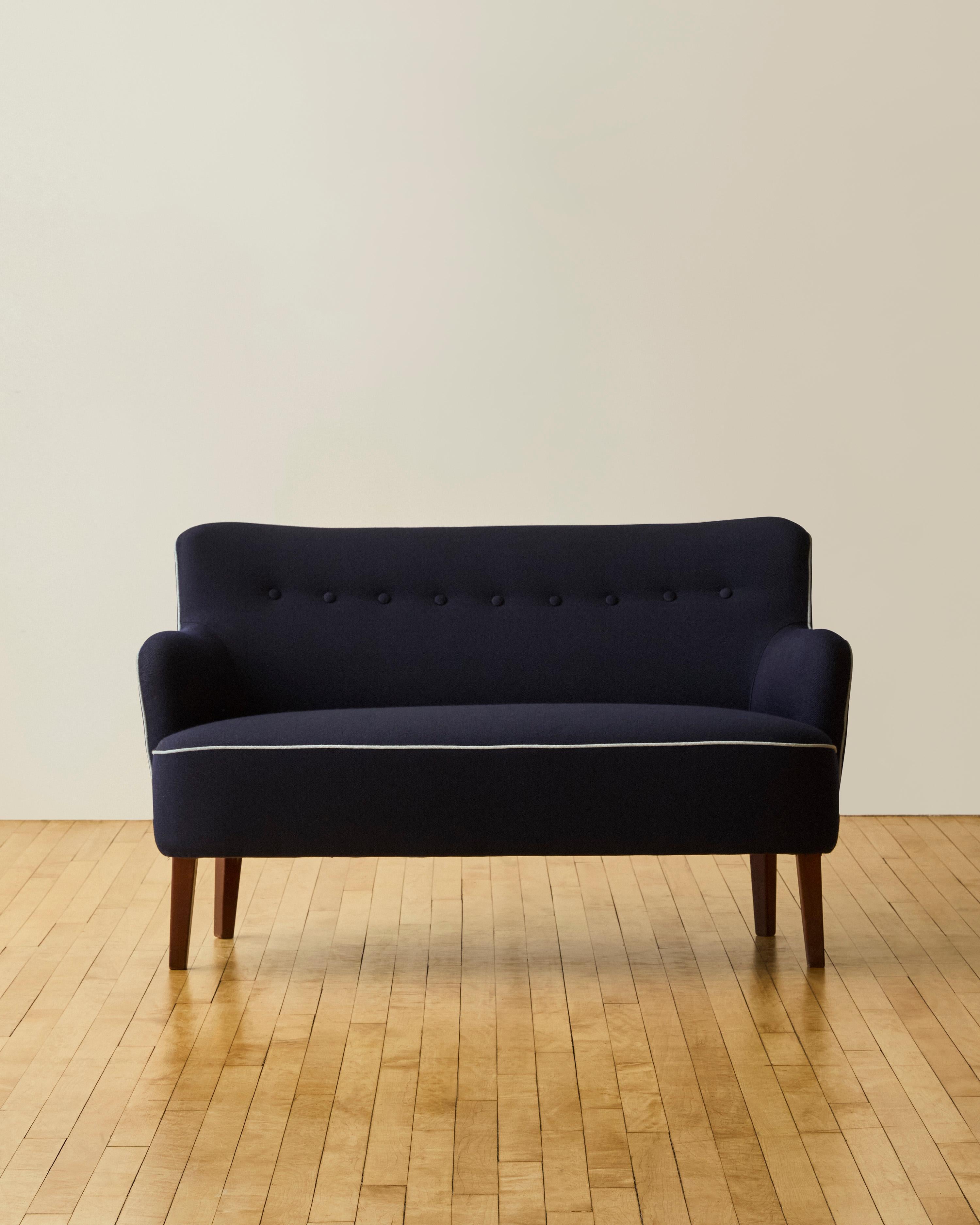 Danish Mid Century Modern Loveseat by Frits Henningsen. Newly reupholstered in Newly reupholstered with Kvadrat blended boucle navy fabric with contrast light blue piping.