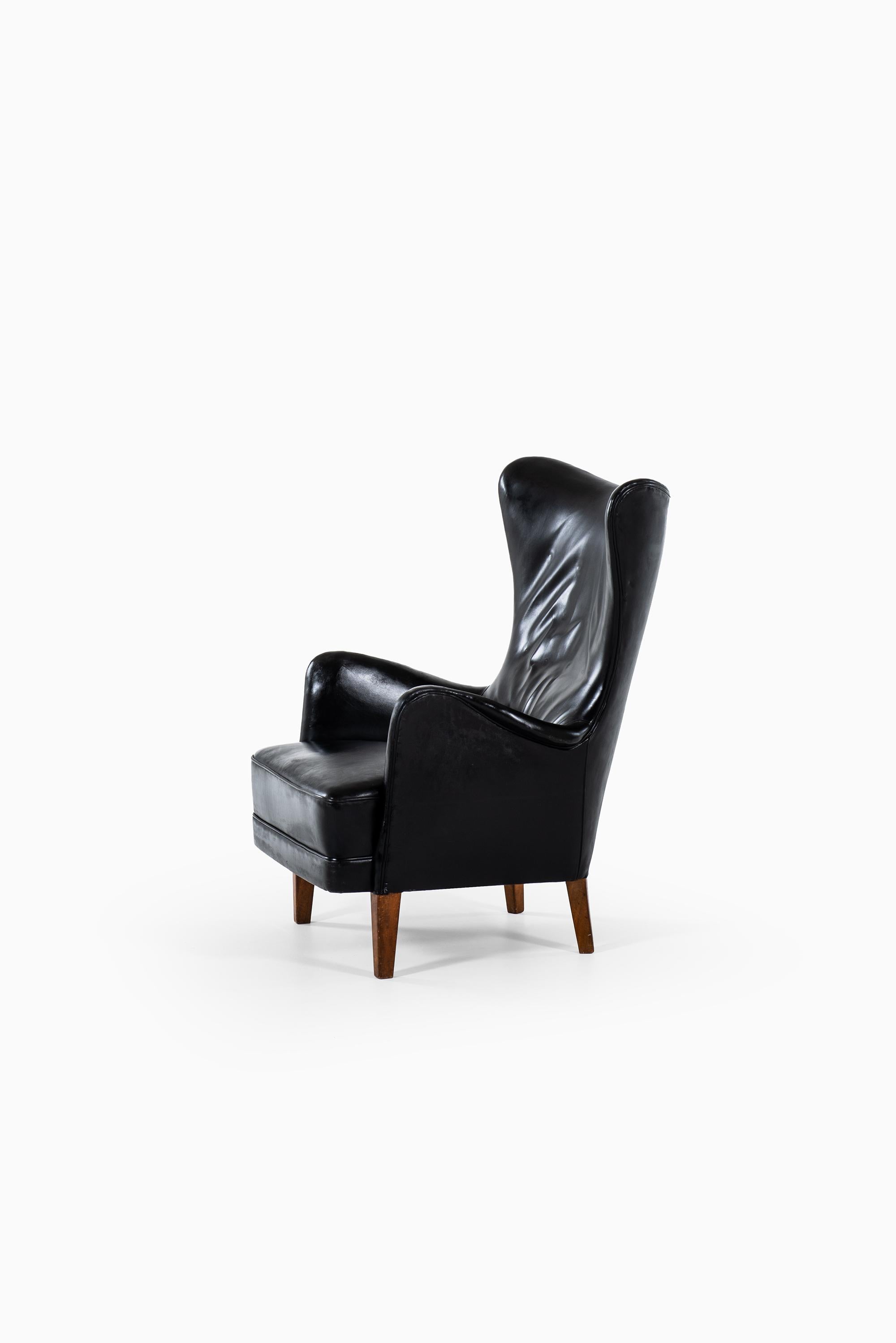 Rare wingback easy chair designed in 1935 by Frits Henningsen. Produced by cabinetmaker Frits Henningsen in Denmark